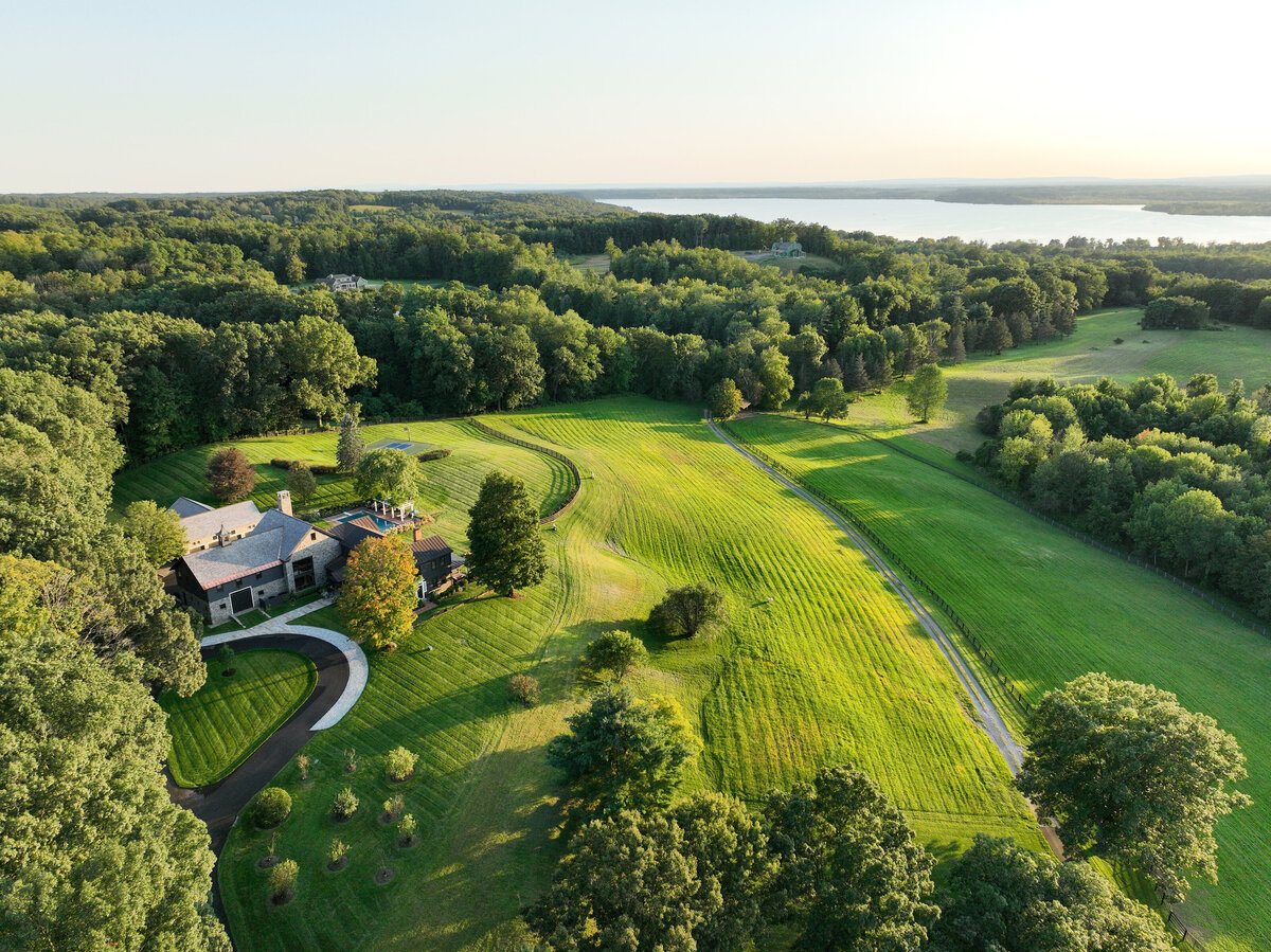 drone view of white house with green manicured lawn