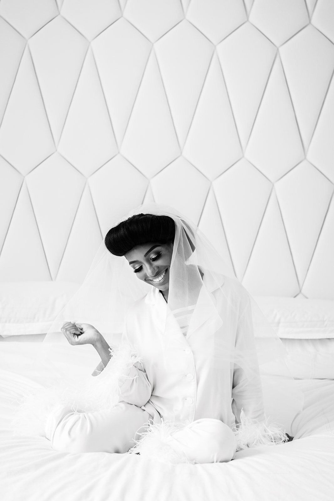 Black and white photo of the bride in a stylish robe, preparing for the ceremony.