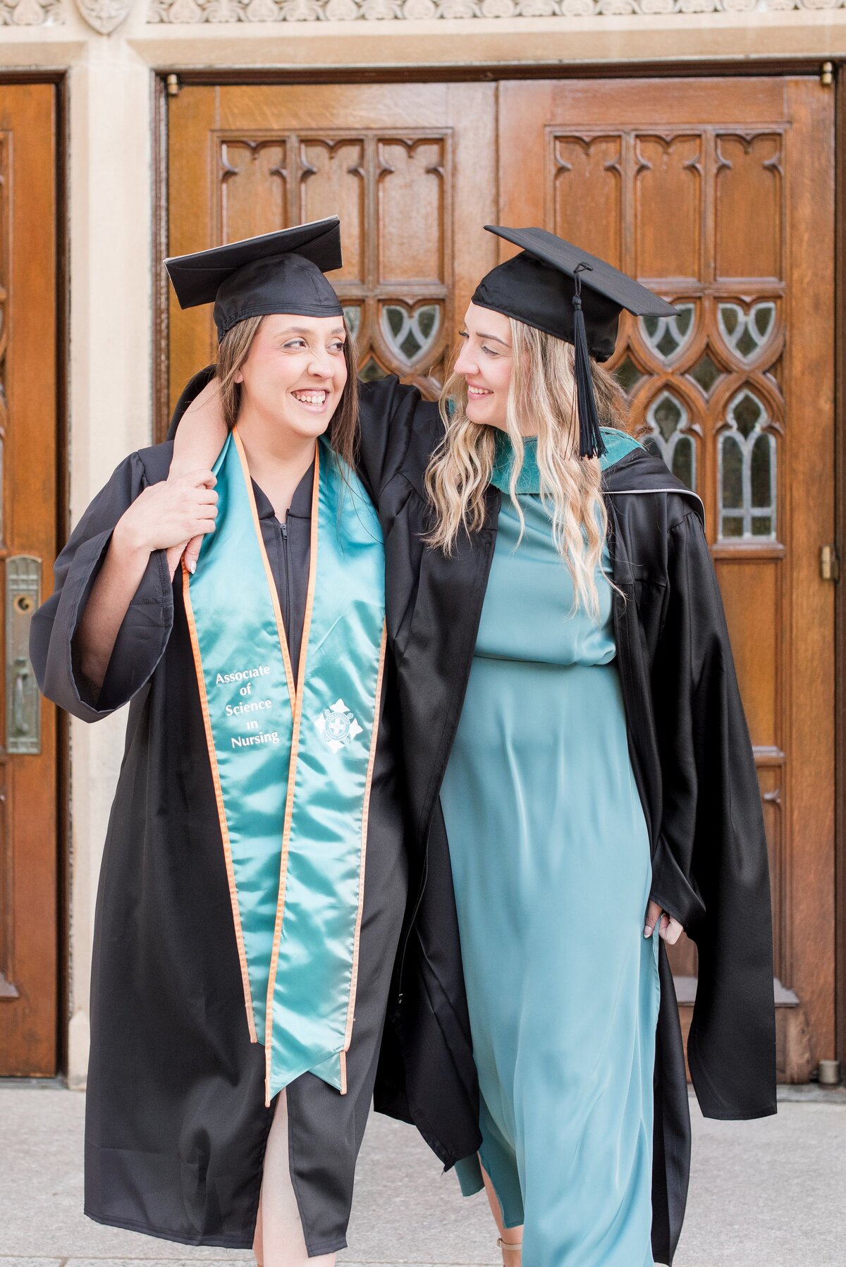 graduate sisters embracing