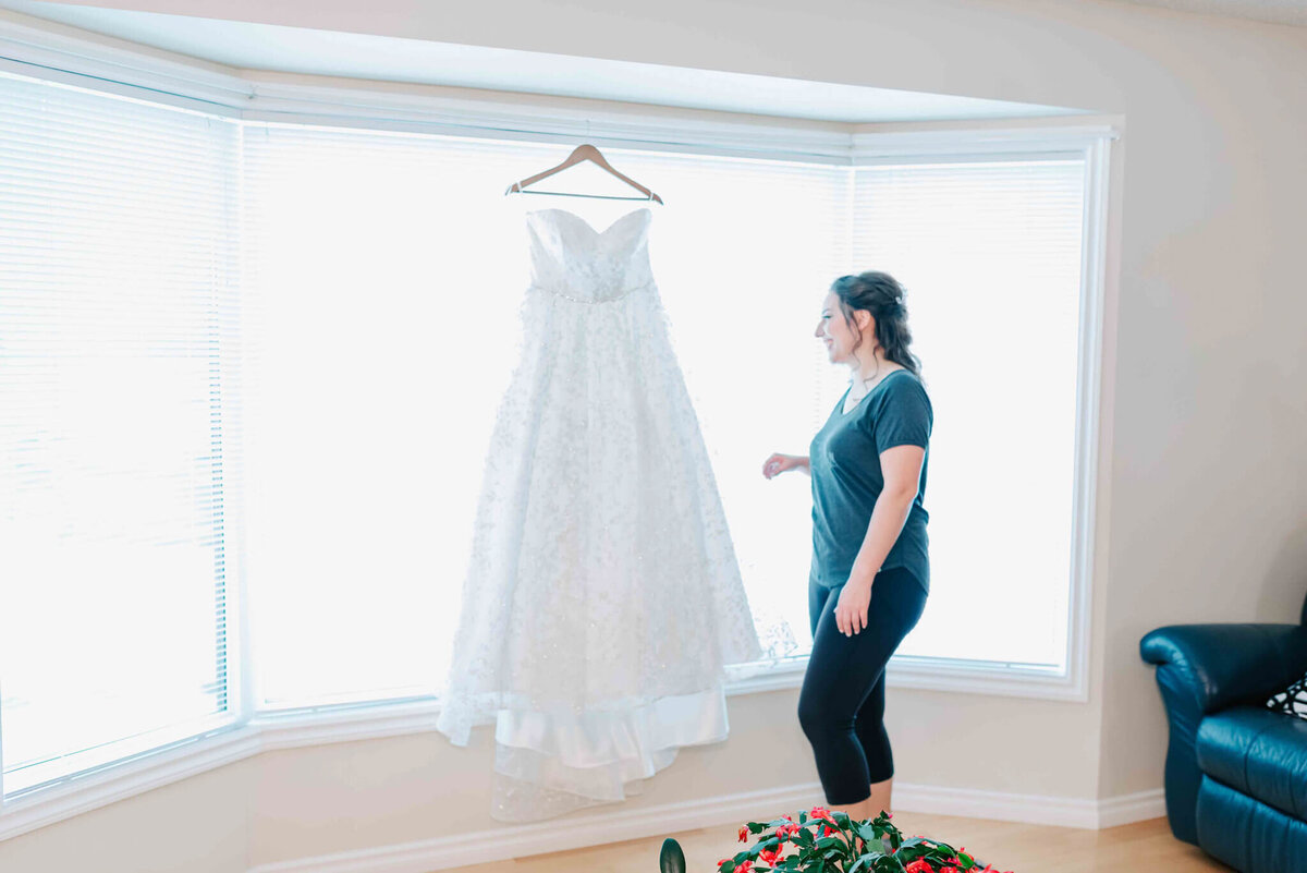 Bride spends a moment with her dress before putting it on. 