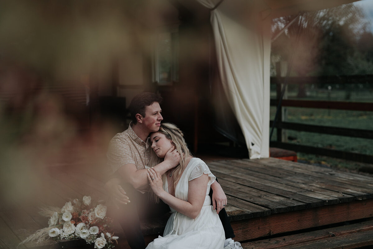 Couple snuggled up on the steps of glamping tent as they finished private vows. 