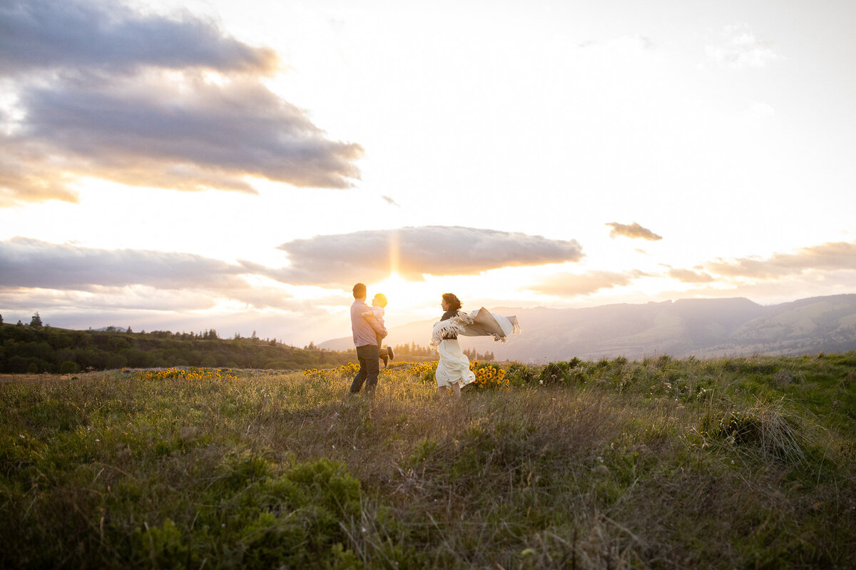 Family dancing in the wind near Portland, Oregon, with a beautiful sunset behind them. 