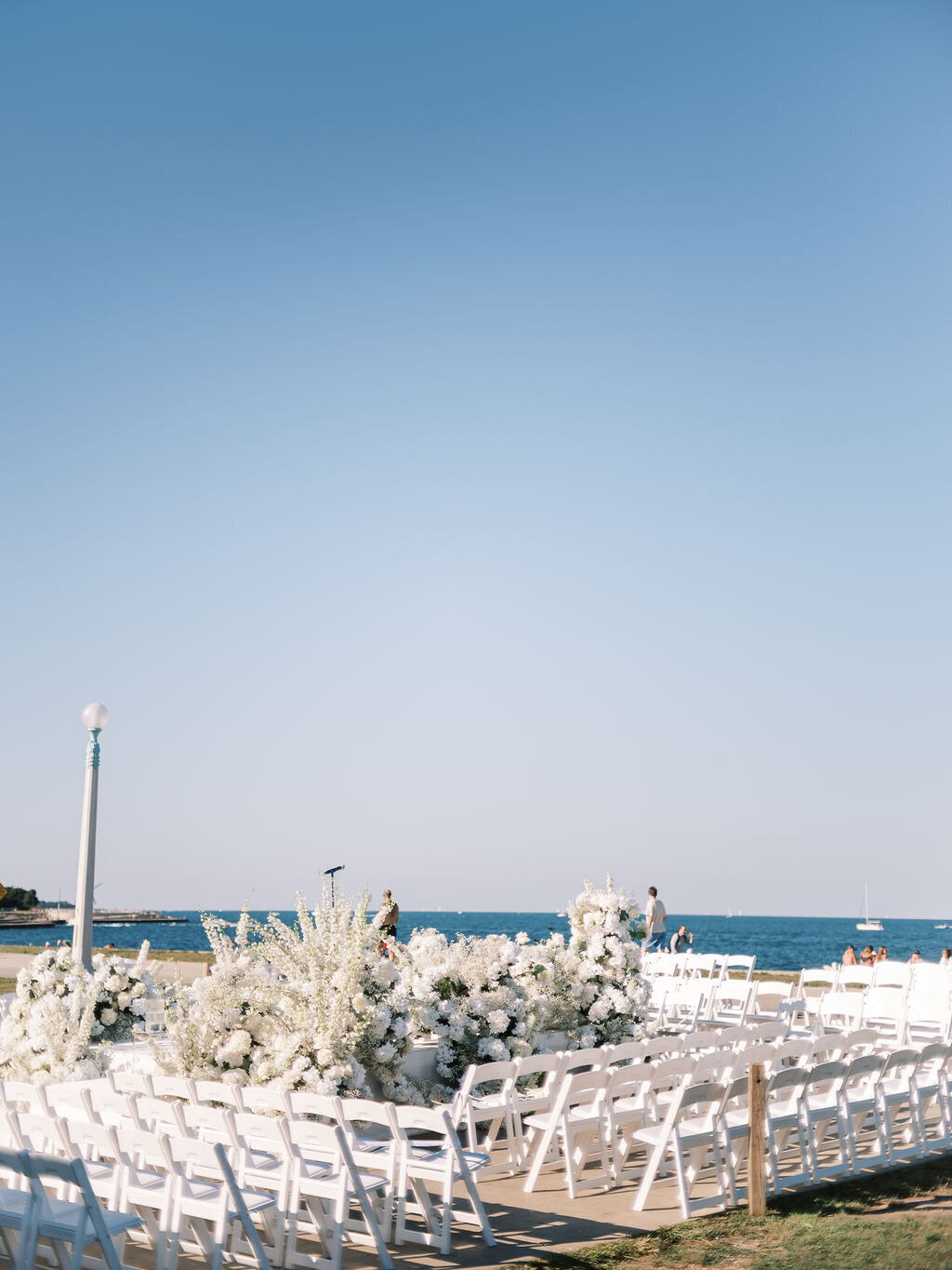 Rows of white chairs and floral arrangements line the ceremony space at Chicago’s Theater on the Lake, overlooking Lake Michigan.