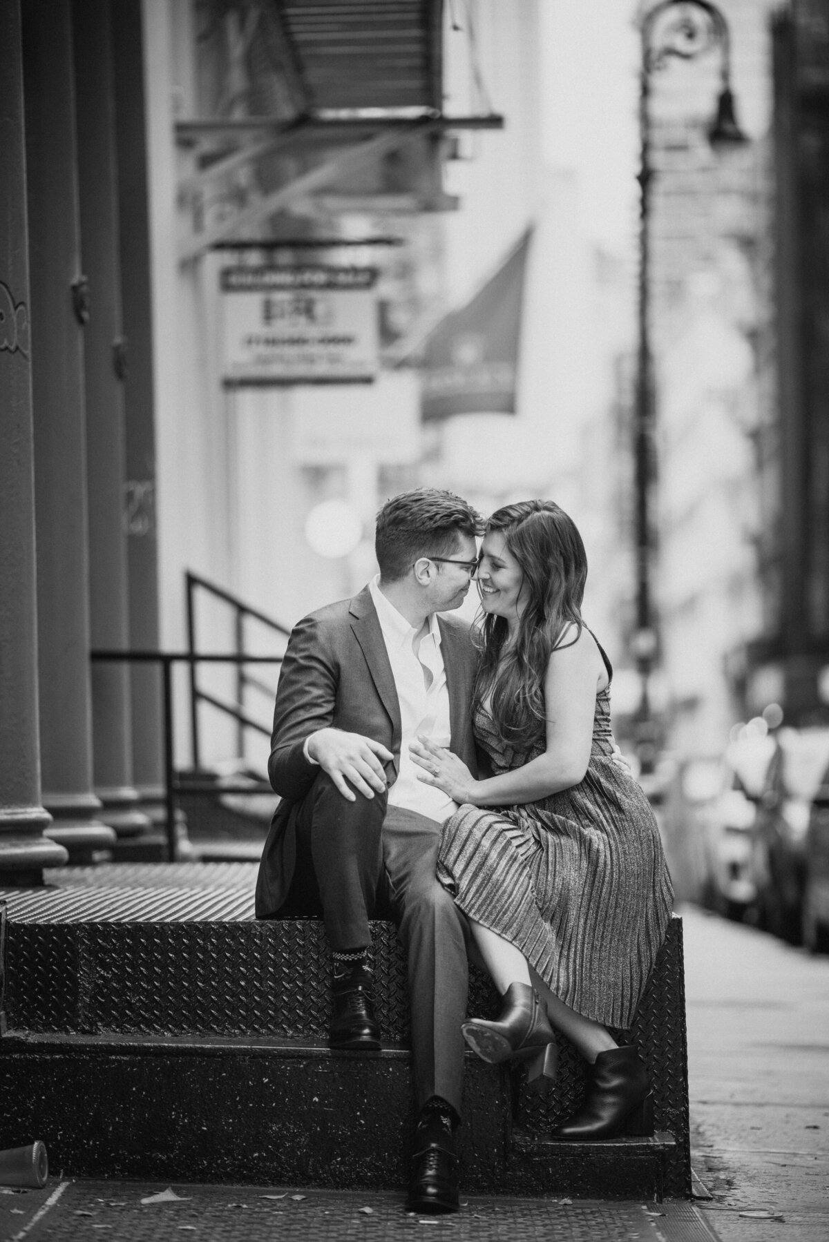 A couple sitting on a small stoop about to kiss.