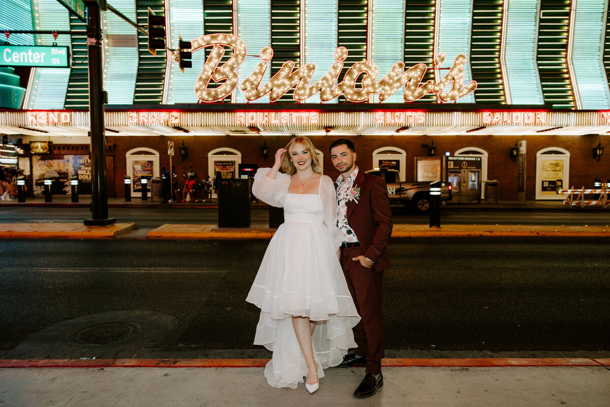 Two people hold hands on their elopement day in front of Binion's in Las Vegas.