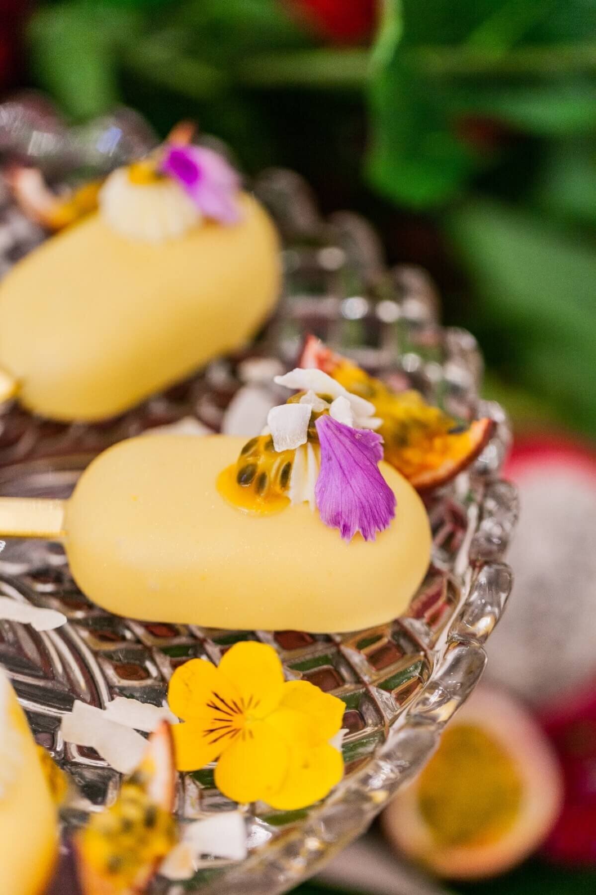 Yellow cake pop decorated with edible flowers