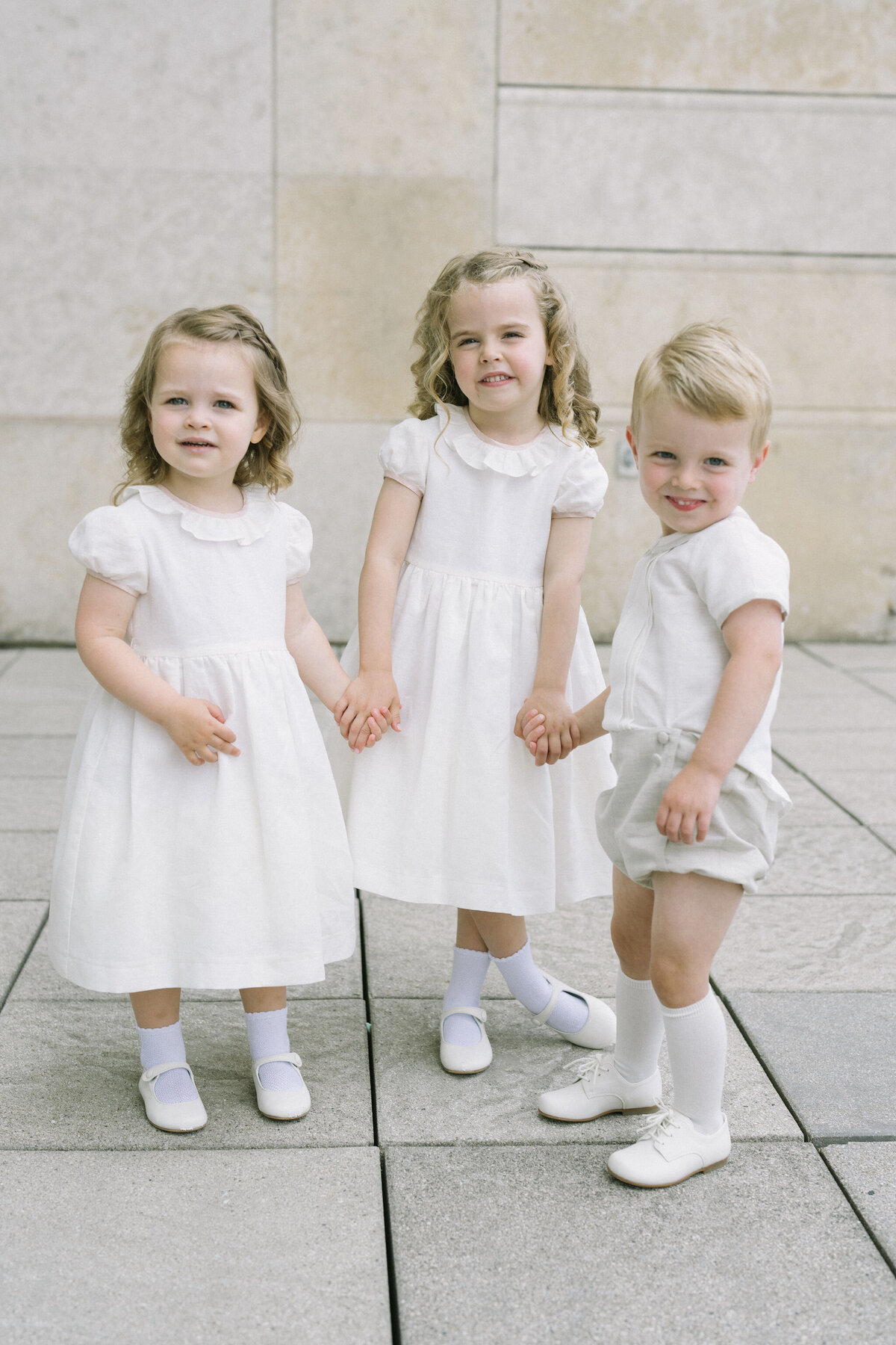 Three young flower girls in white, ready for the wedding at Saddle Country Club.