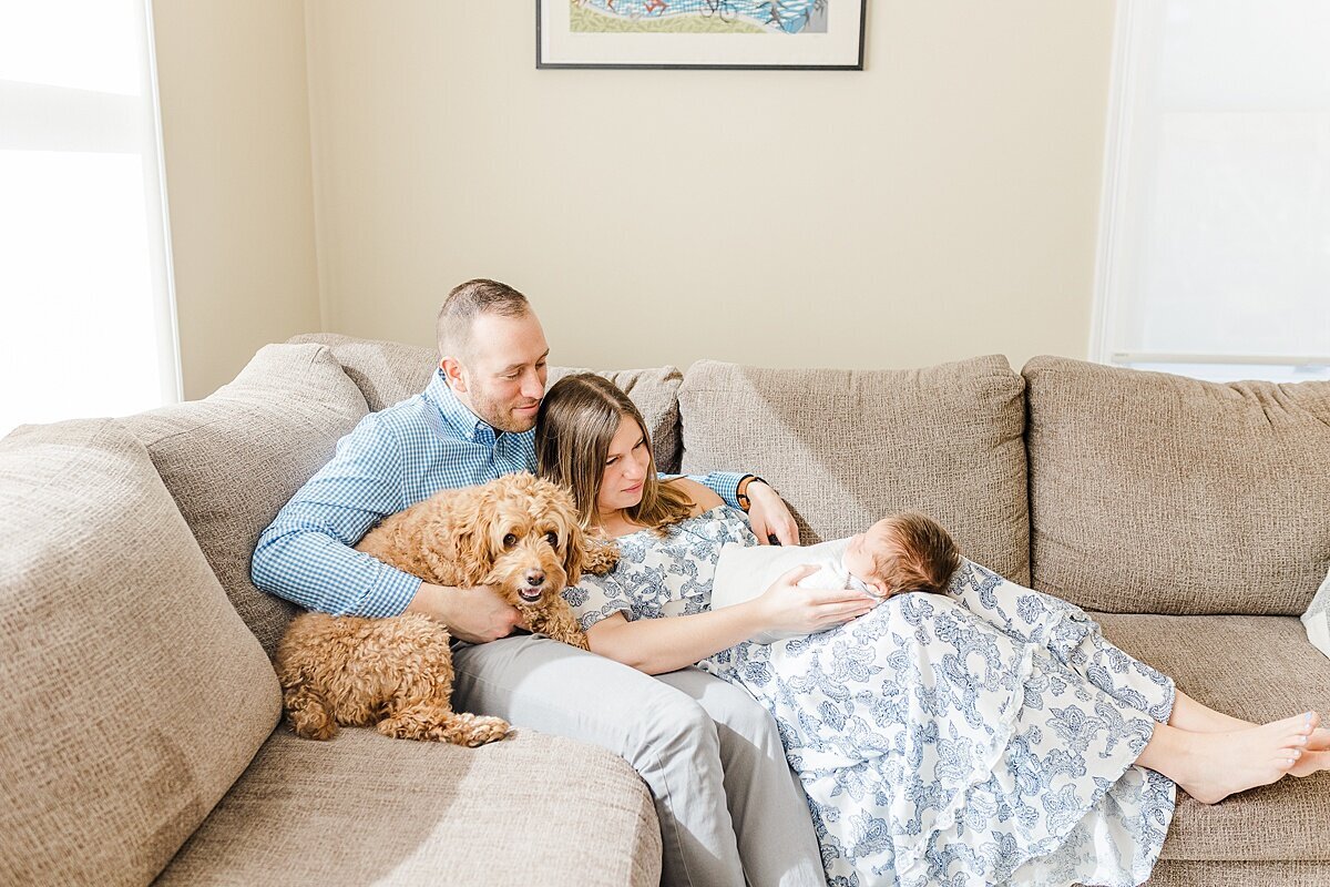 family sits on couch during in home newborn photo session with Sara Sniderman Photography  in Natick Massachusettts