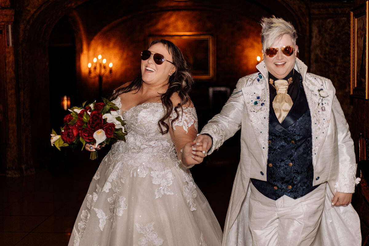 LGBTQ brides wearing sunglasses and rolling into their recption in style