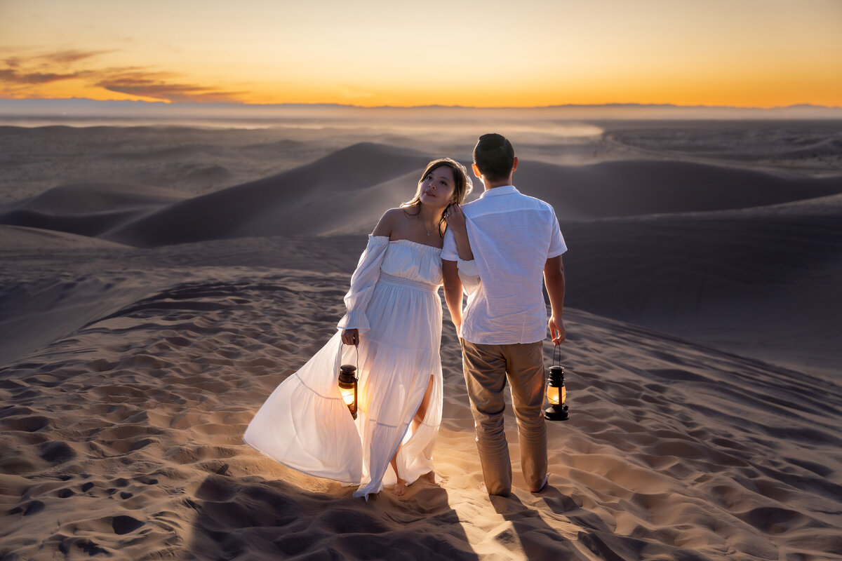 Glamis Sand Dunes elopement bride and groom during sunset holding lanterns.
