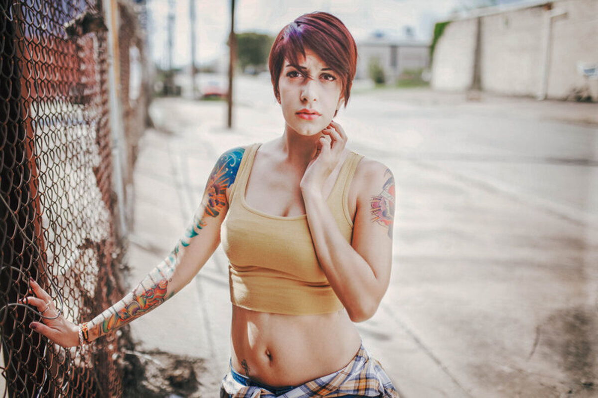 Tattooed woman with short hair posing in an urban outdoor location during a Central Florida portrait session.