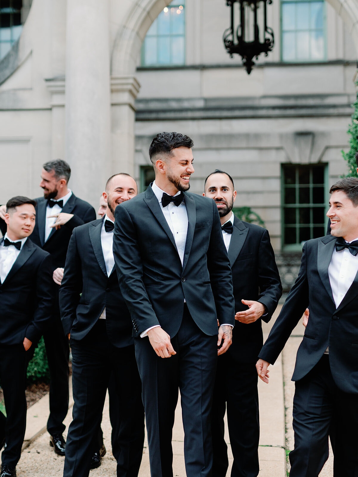 Groom and his guys walking in front of their wedding venue.