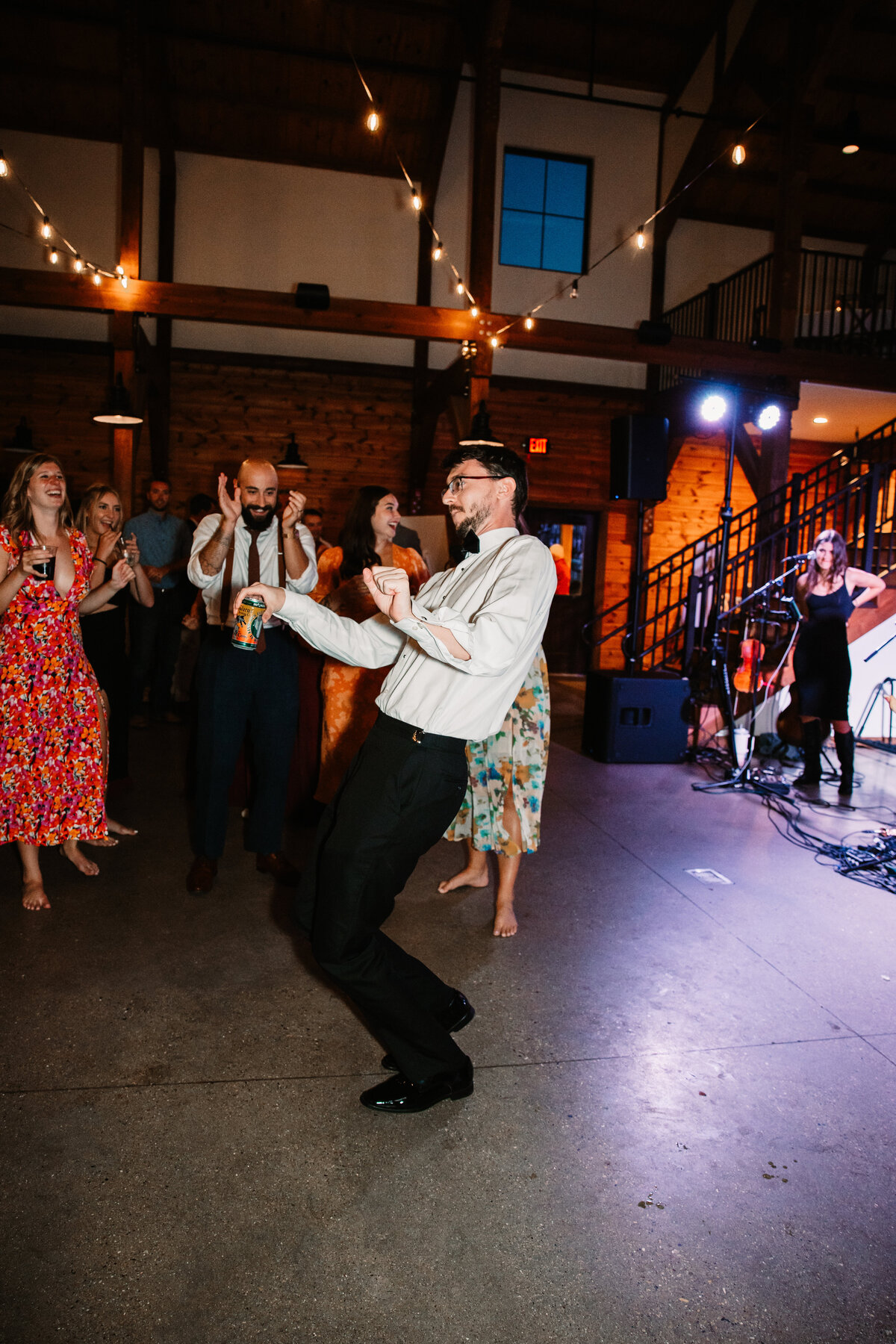 A man dances in front of everyone at a wedding reception