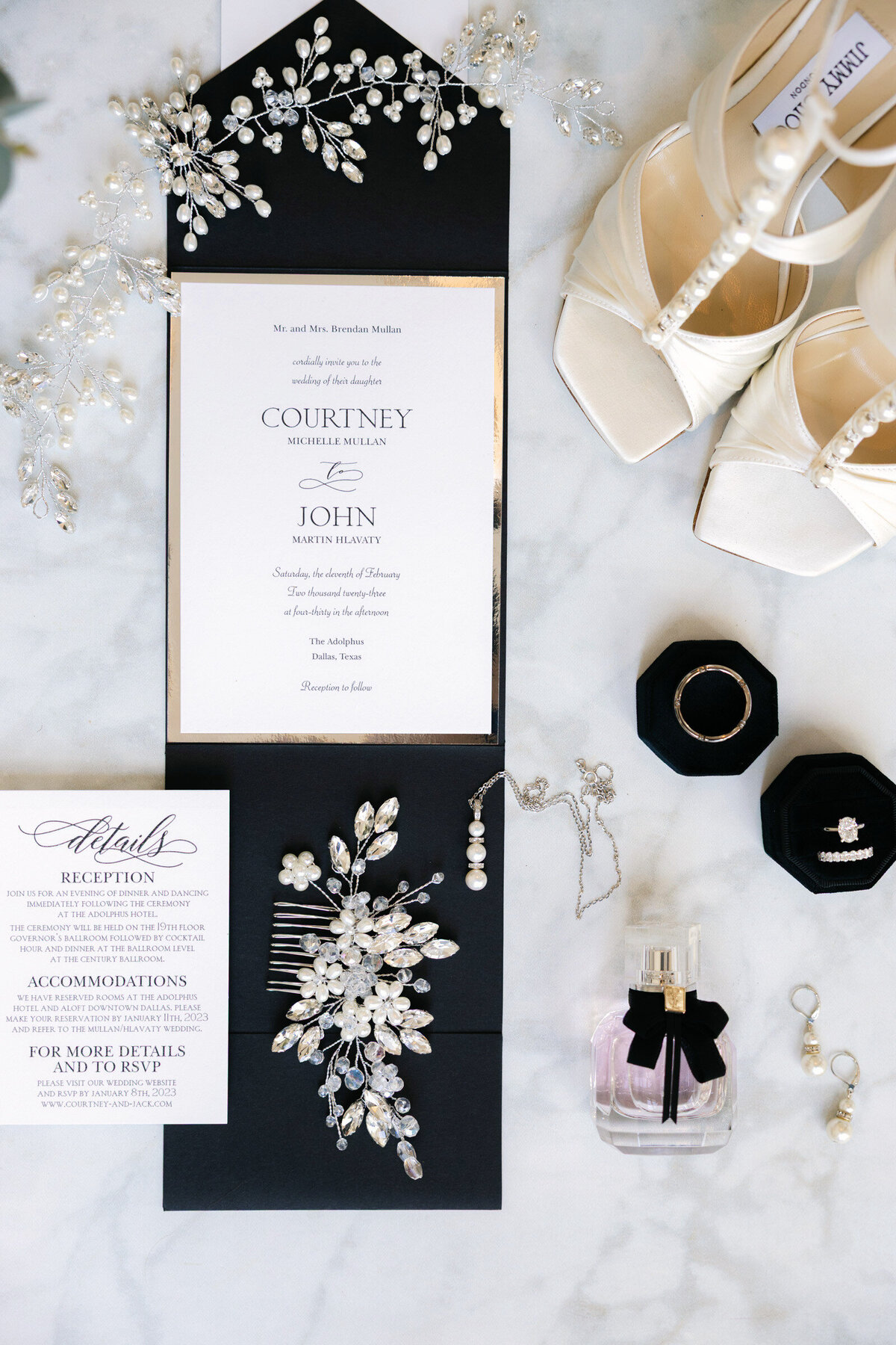 flat lay of wedding details at The Adolphus in Dallas including Jimmy Choo shoes, wedding invitation, hairpiece, YSL perfume, rings, and pearl jewelry, showcasing elegant bridal accessories for a luxury wedding.