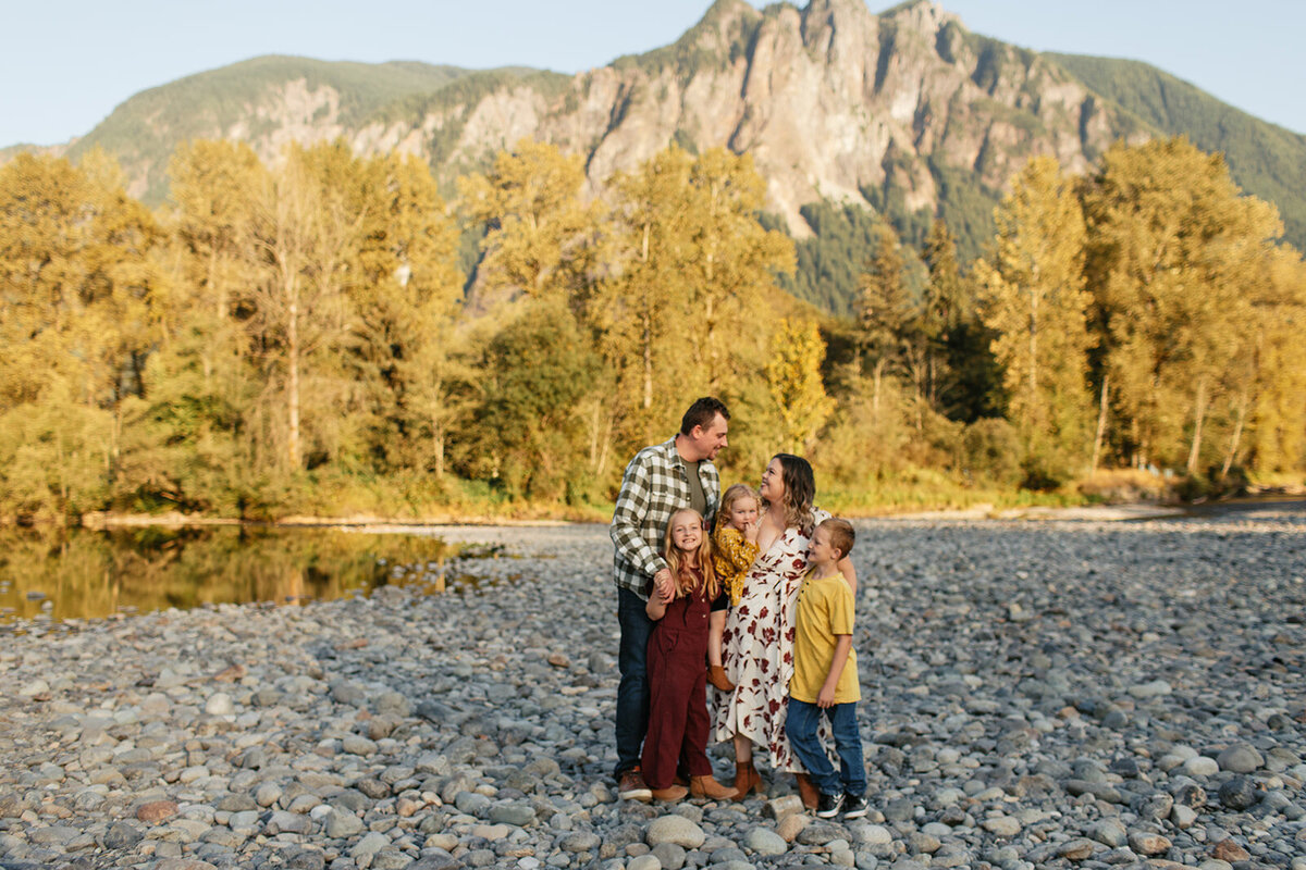 Family of 5 standing against a mountain range during a family photo shoot near Seattle.