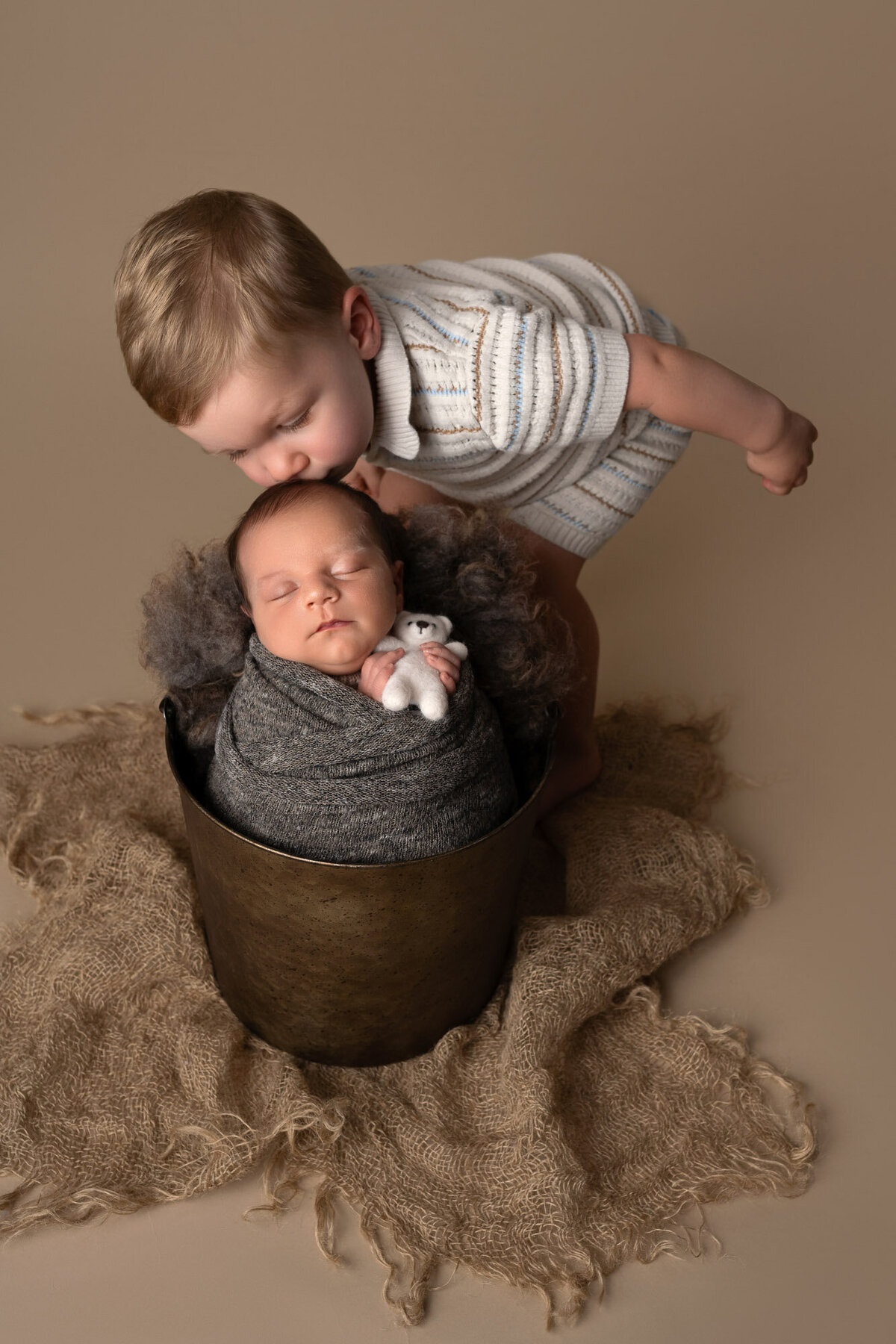Big brother meeting newborn bucket pose Lakeway sibling photographer