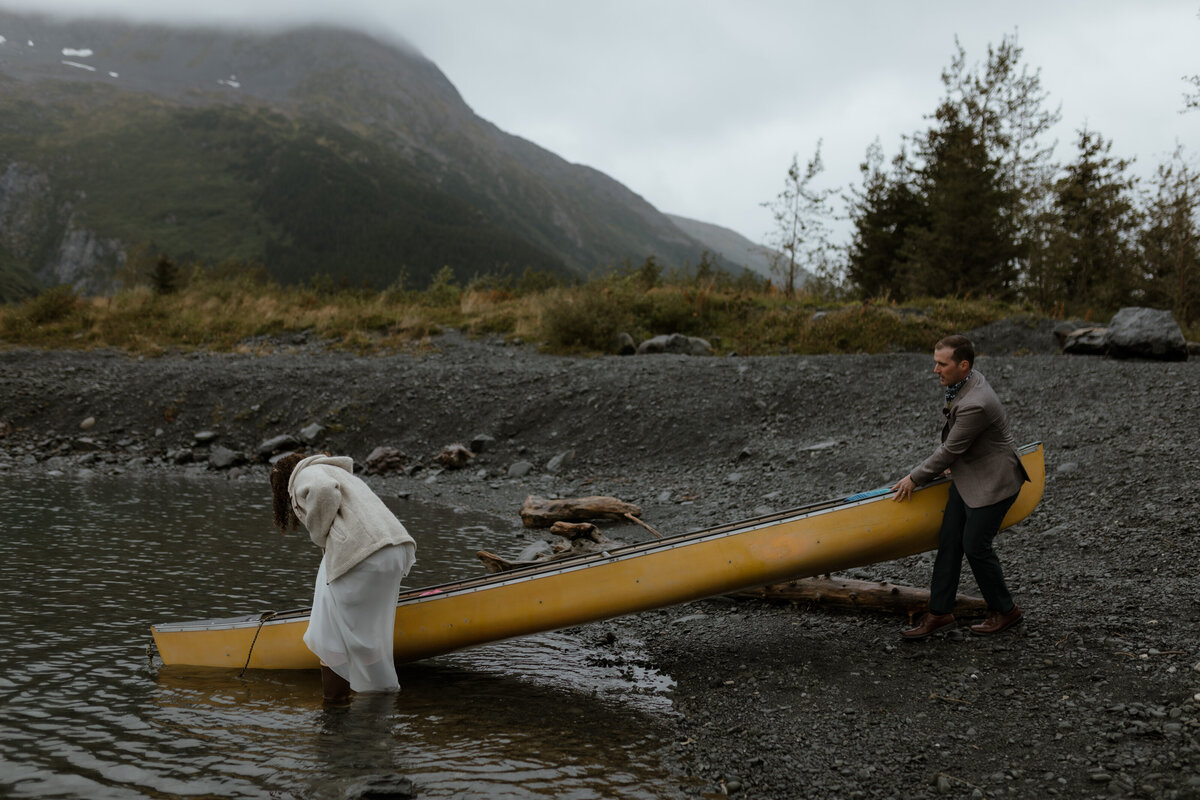 Bride and groom carrying canoe