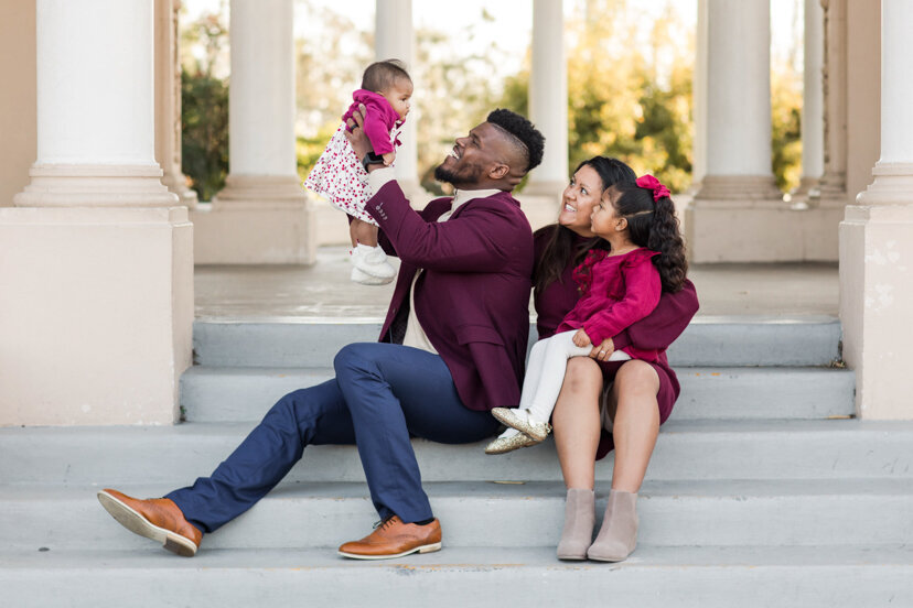 parents sitting at organ pavilion holding up young daughter