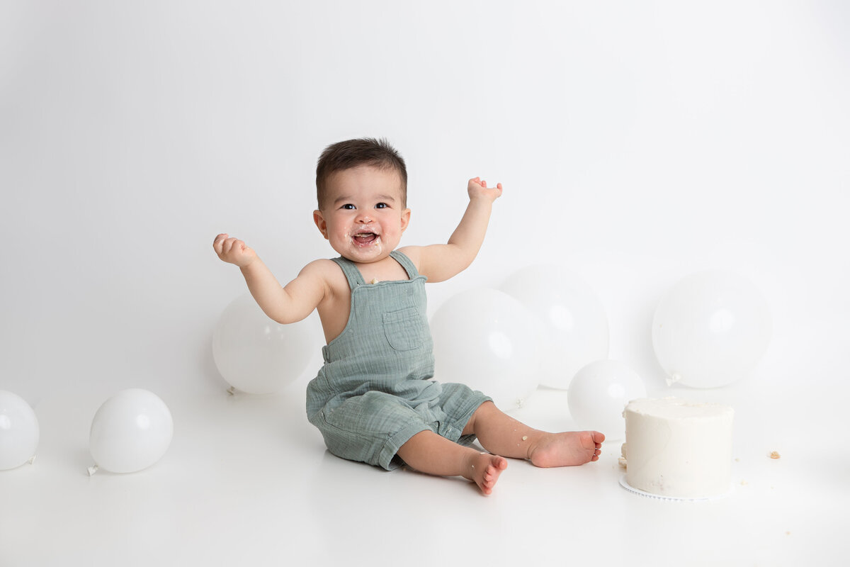White backdrop and white balloons simple cake smash set up