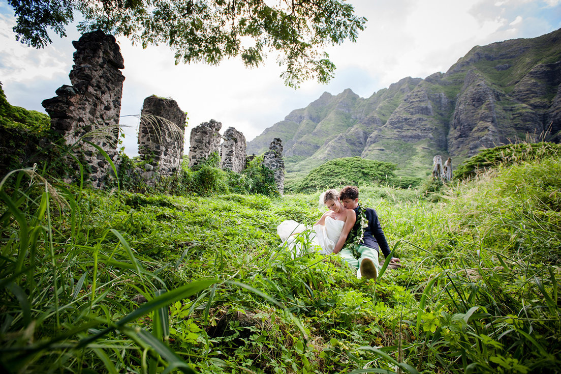 married couple in grassy field by ruins