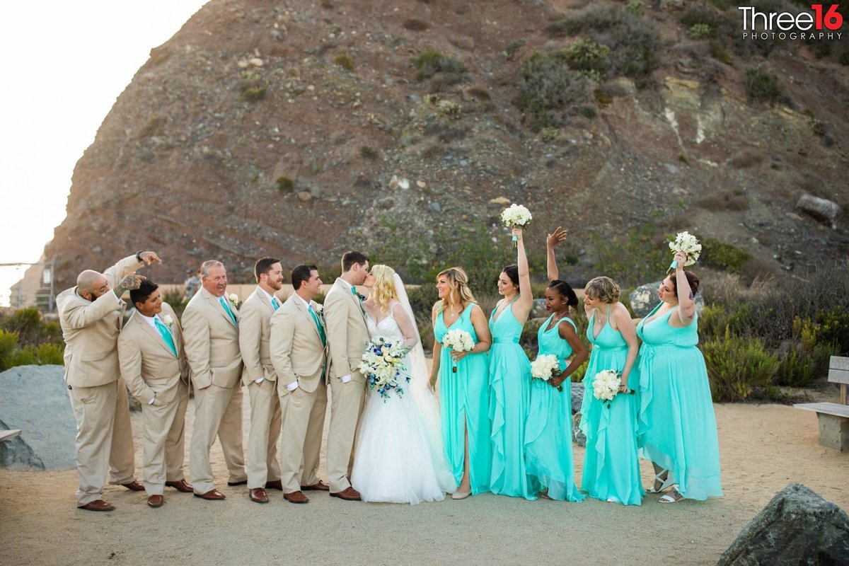 Bridal Party cheer when the Bride and Groom share a kiss while standing on the beach down the cliff from the Ocean Institute