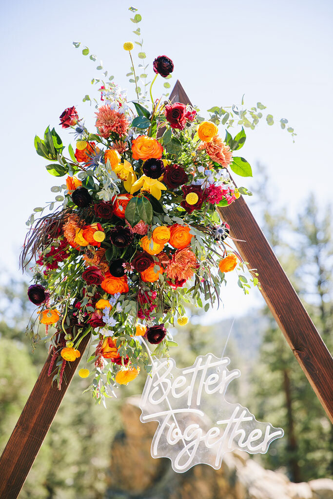 Colorful flowers and neon sign on wooden triangle frame