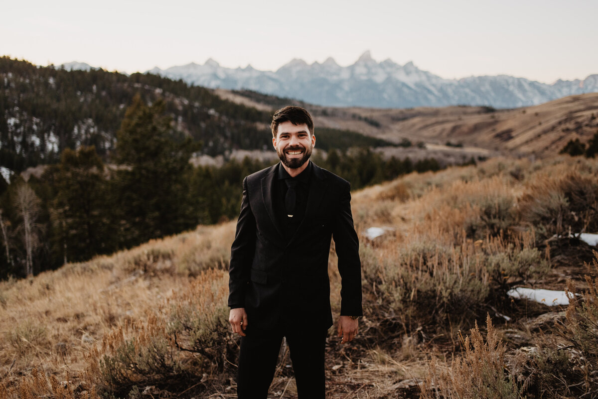 Jackson Hole Photographers capture groom smiling in Tetons during portraits