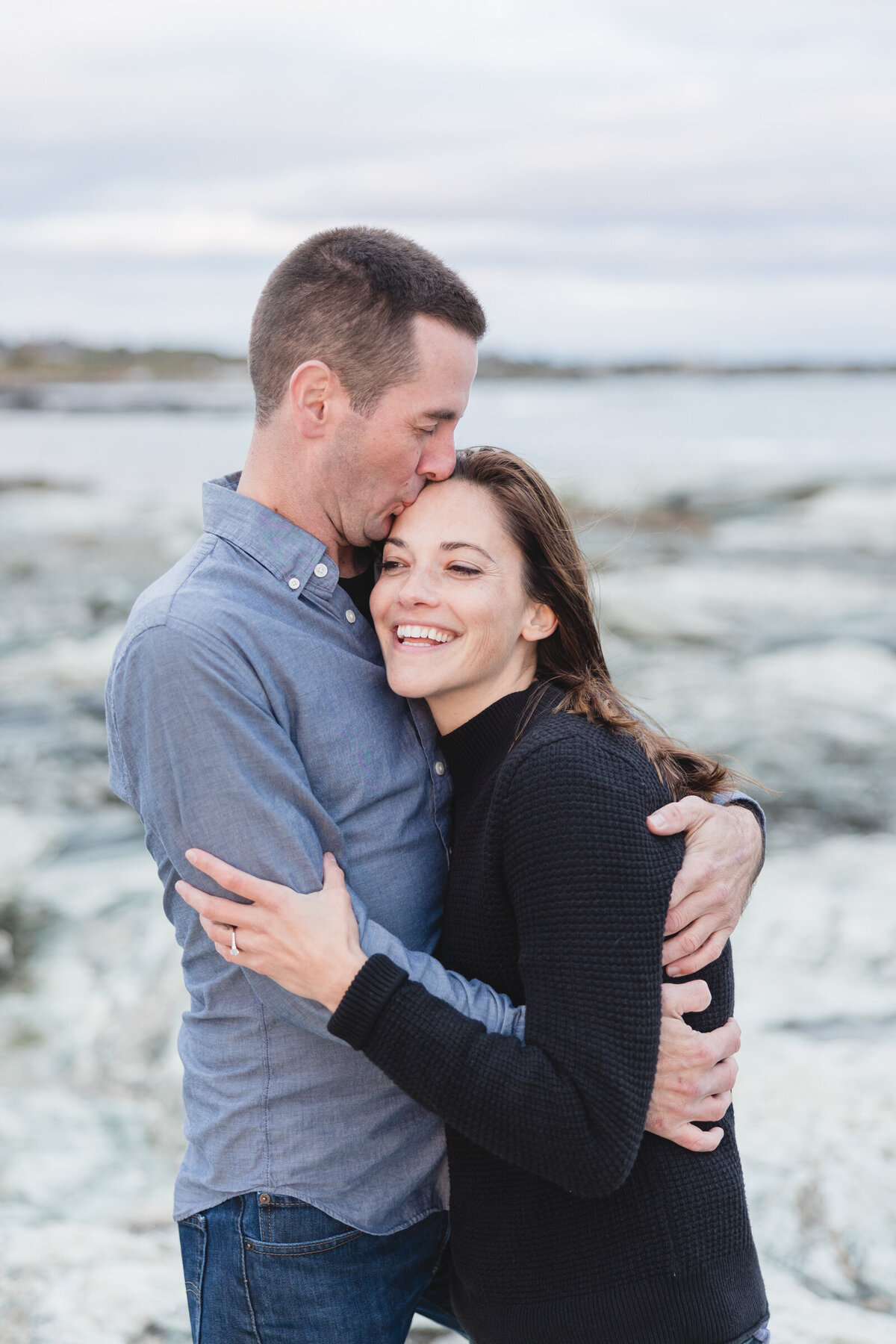 A man kisses his fiancee on the coast of Brenton Point Park