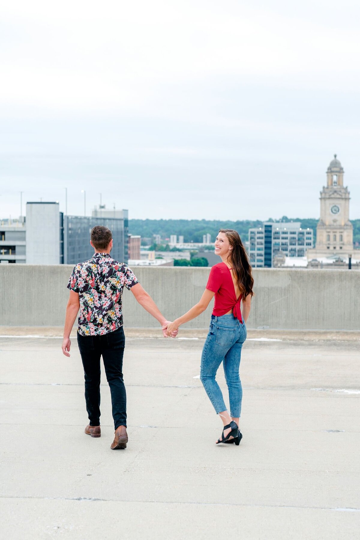 couple-laughing-holding-hands-rooftop-engagement