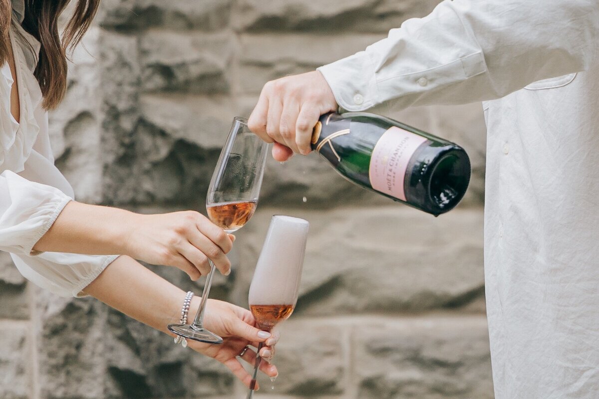 Engaged couple popping champaign at their engagement session by NovaMarkina Photography
