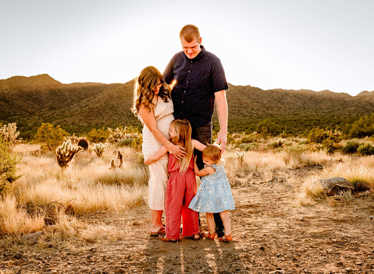 AZ family hugging tight in AZ desert while being photographed for family session