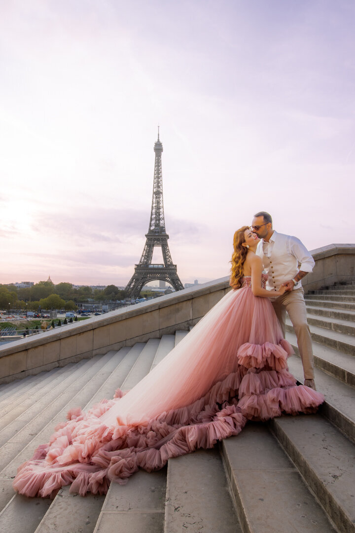 Paris couple photo session on stairs, light pink princess dress, Eiffel Tower view, romantic photography moment
