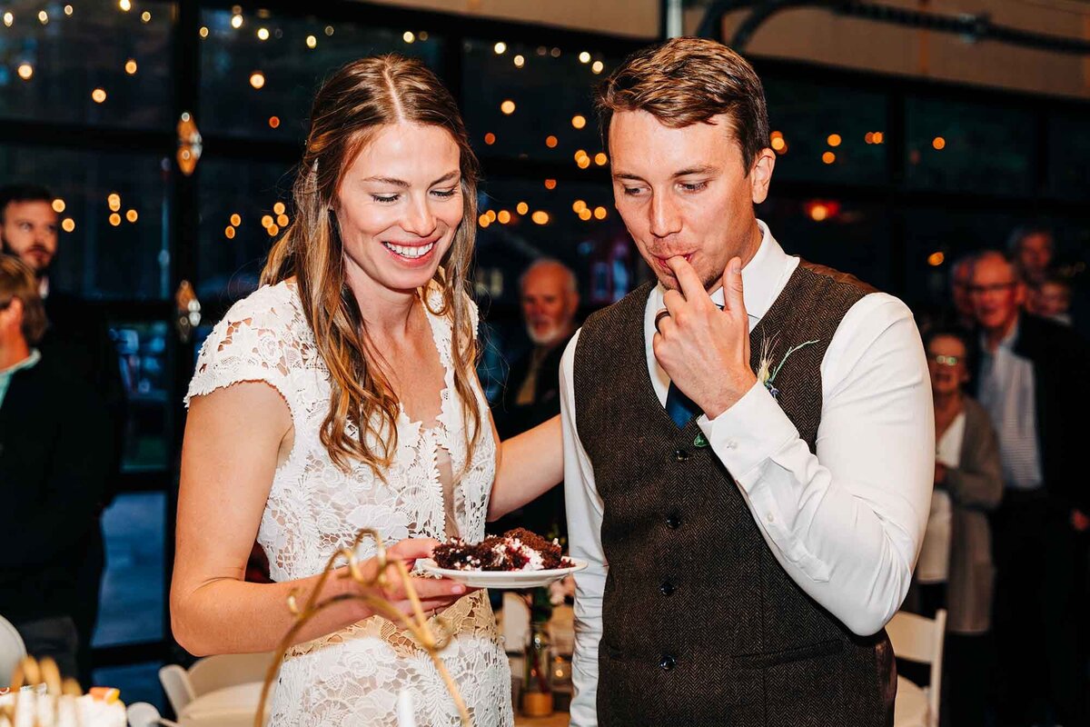 Bride and groom eating cake at wedding reception, Izaak Walton Inn, Essex, MT