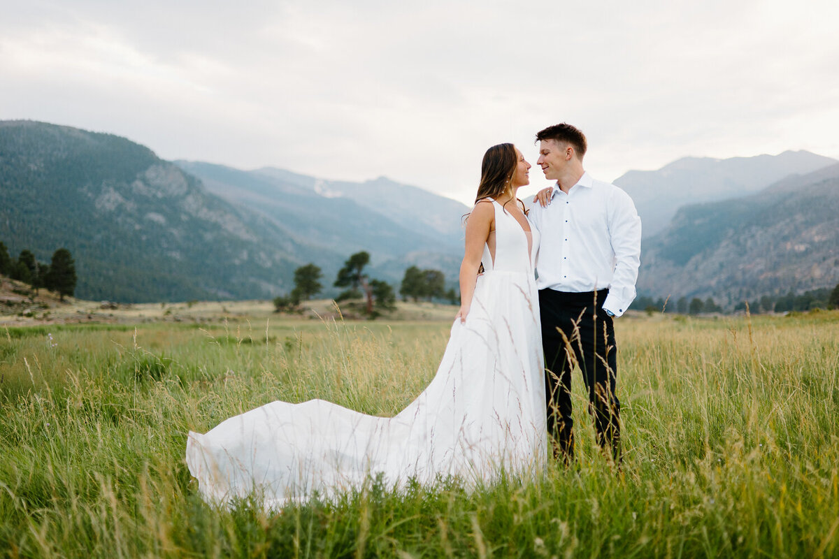 A joyful bride and groom gaze at each other lovingly during their Colorado mountain wedding photography session.