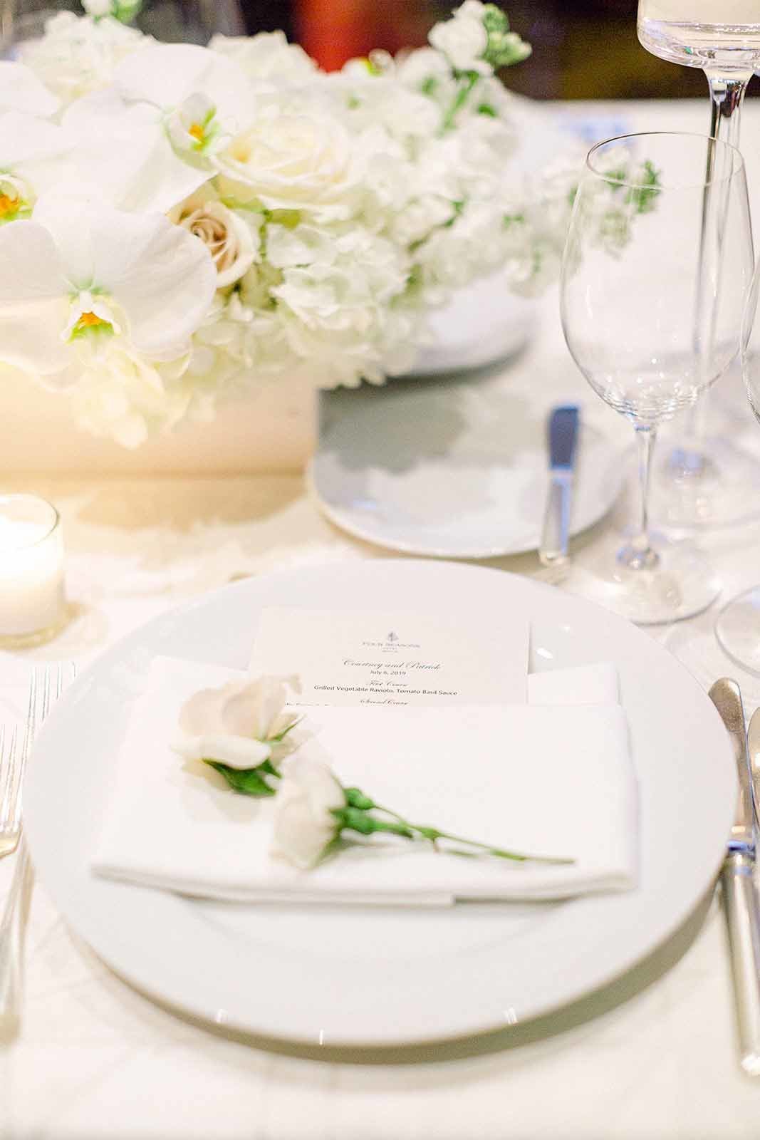 place setting with fresh roses on napkin
