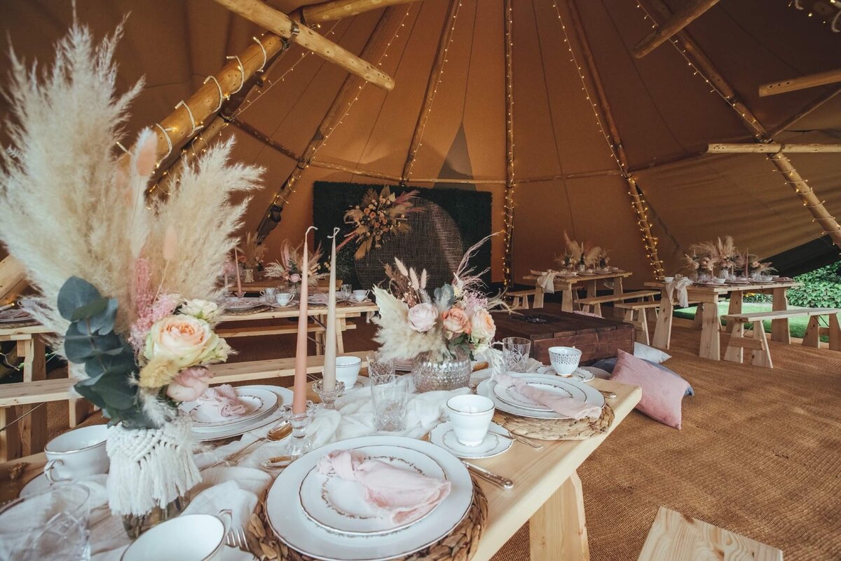 Luxury afternoon tea table setting with pink napkins and candles with pampas grass flower decoration