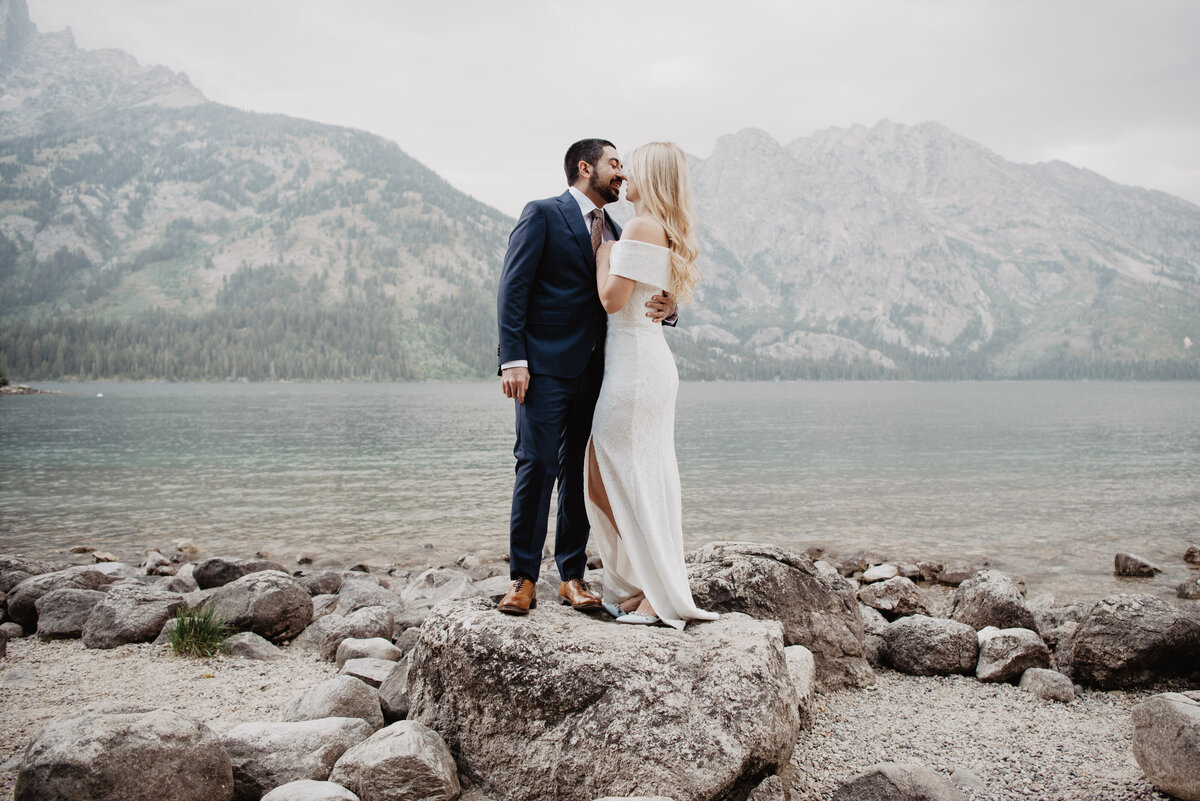 Photographers Jackson Hole capture bride and groom kissing on rock