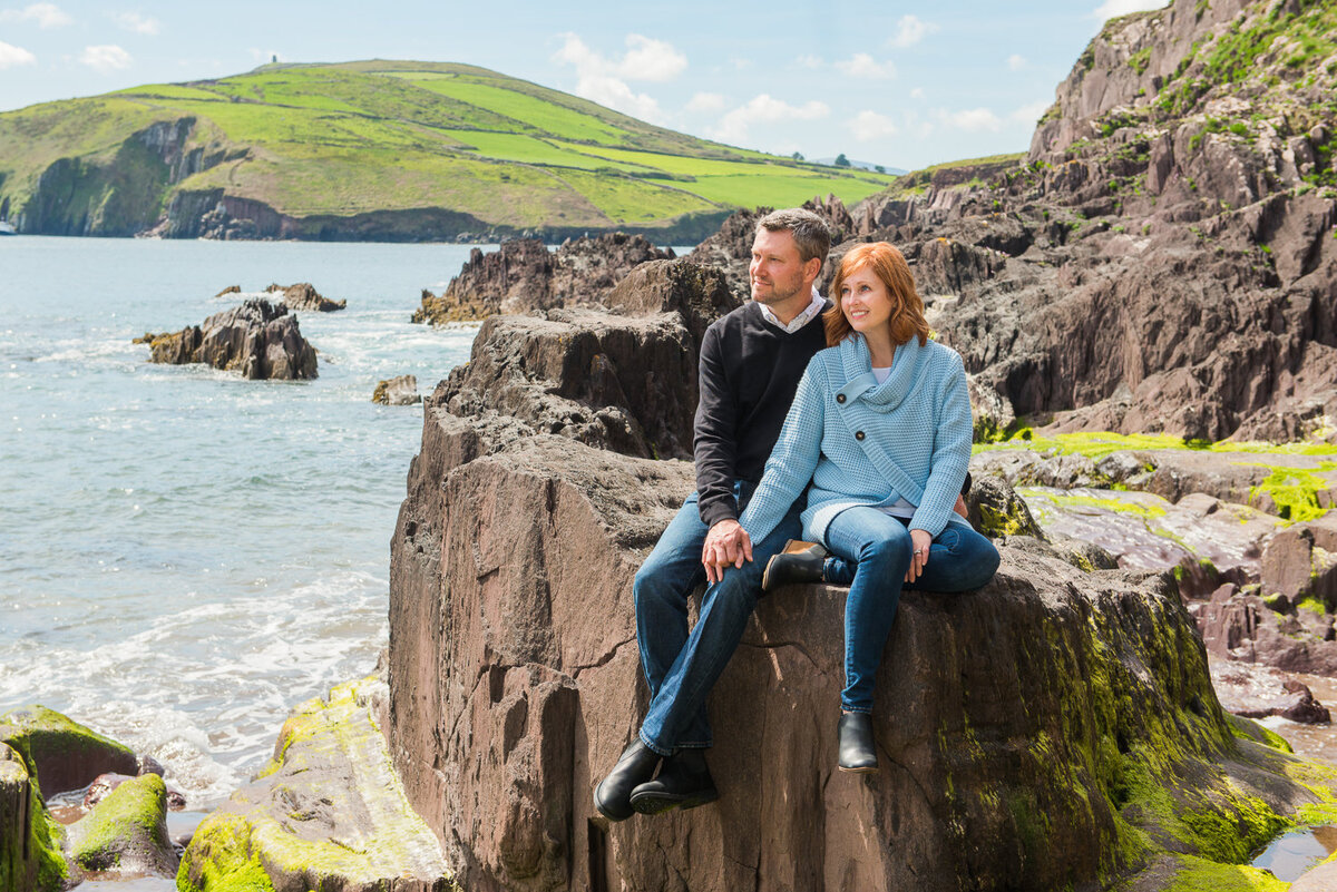 male and female couple sitting on a rock on a beach in Ireland wearing denim