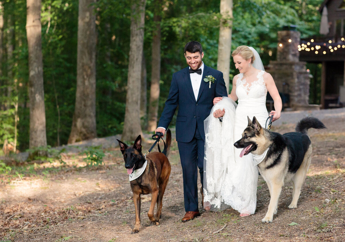 The bride and groom walk through the woods in Bumpass Virginia during a cozy elopement with their two dogs as Best Dog and Dog of Honor.