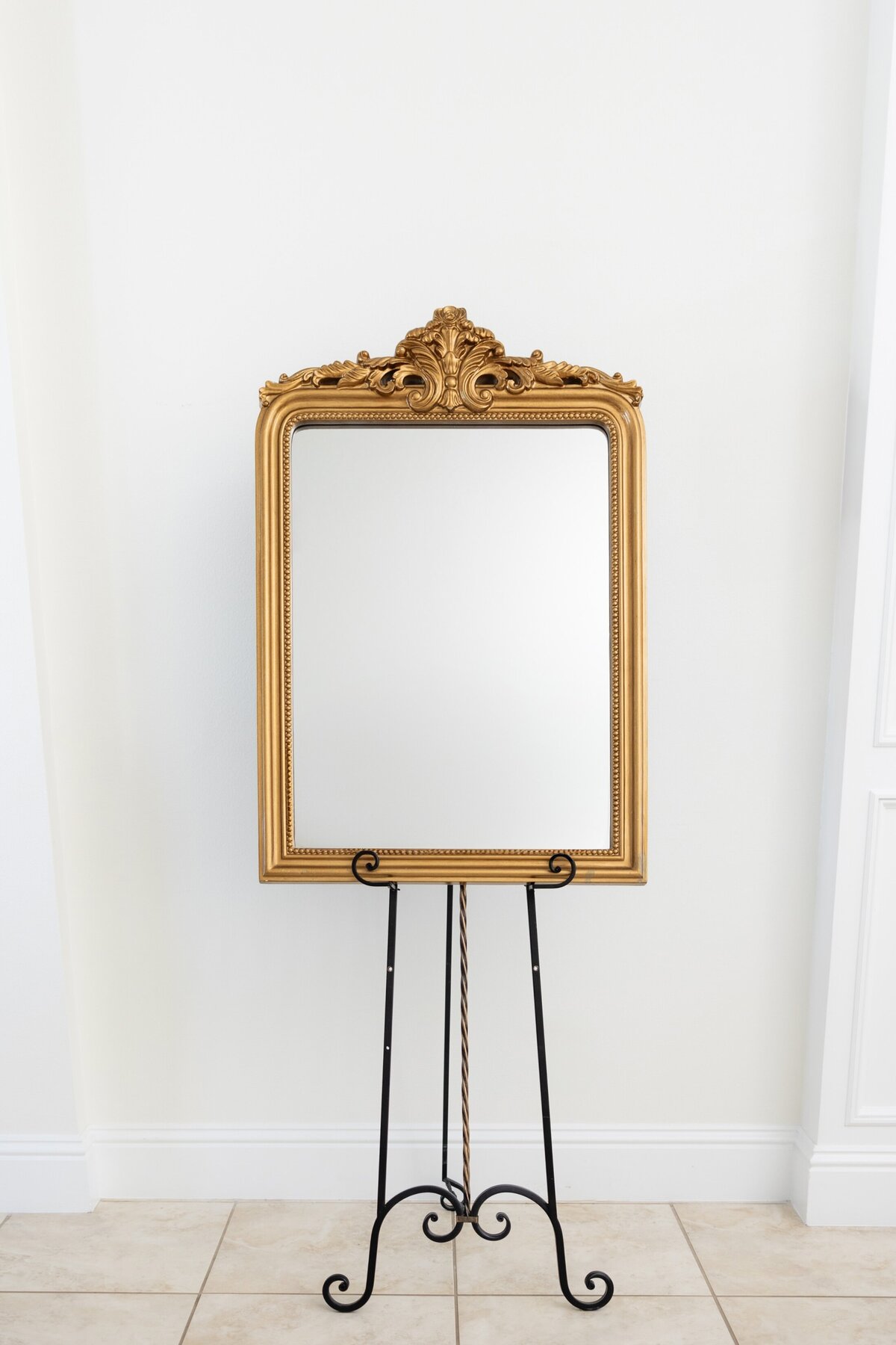Medium vertical mirror with ornate ornament on top 