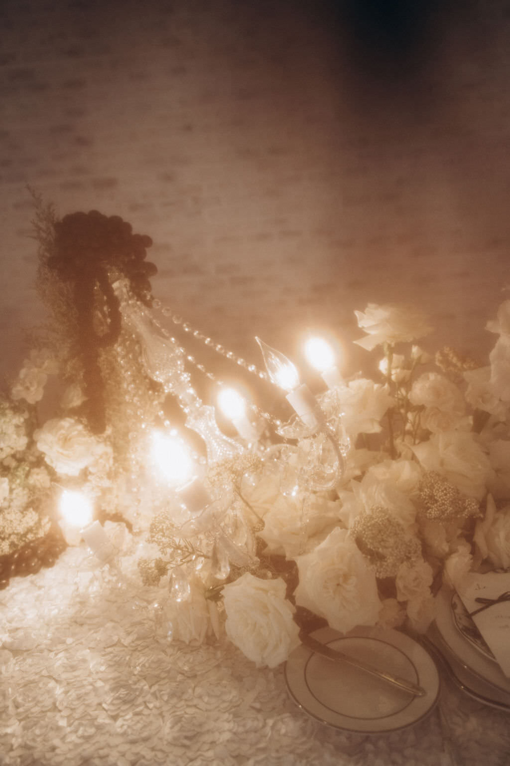 A chandelier laying on a table with flowers.