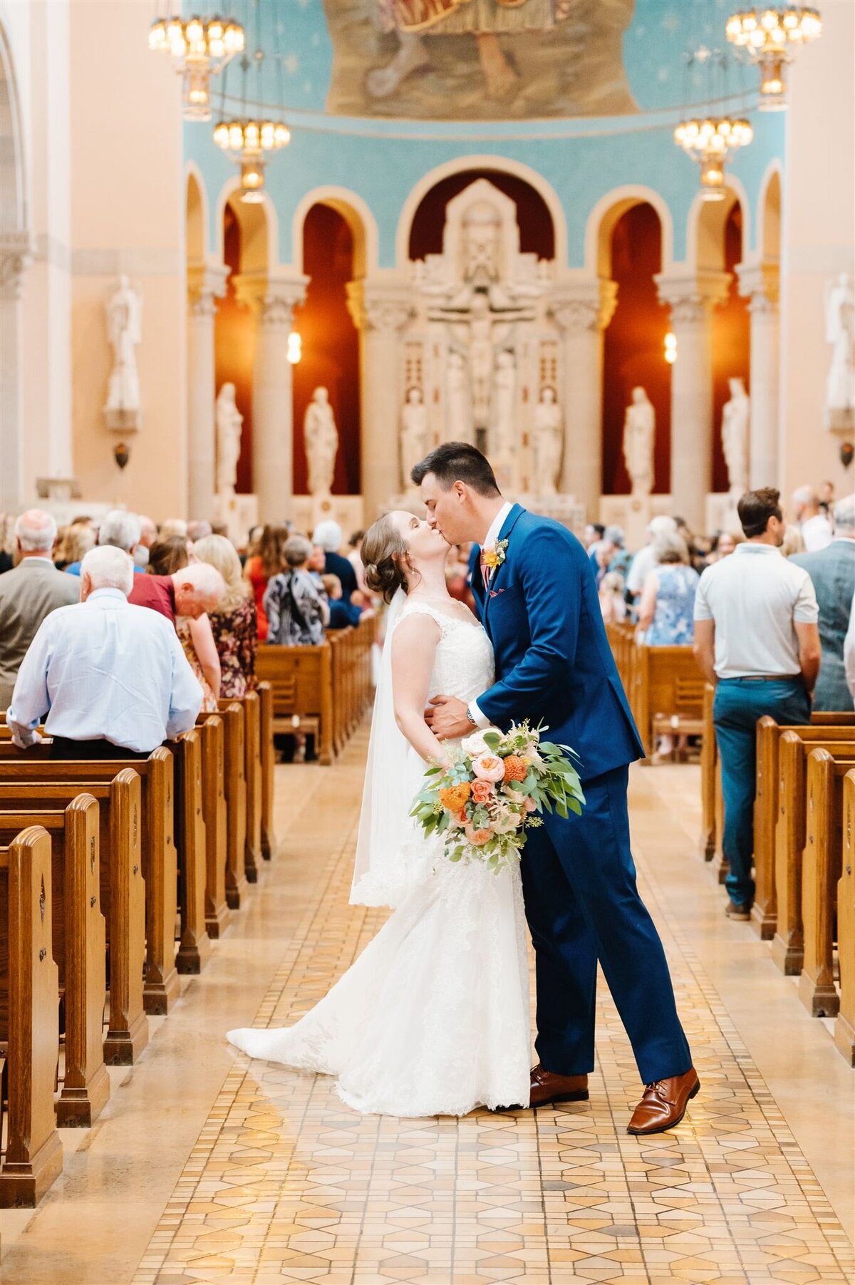 bridde and groom kiss down the aisle at St. PAul church in Minnesota