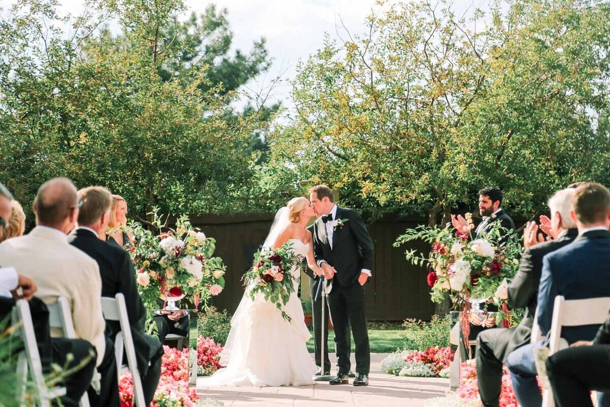 Bride and groom kissing during the wedding ceremony at an outdoor venue in Colorado