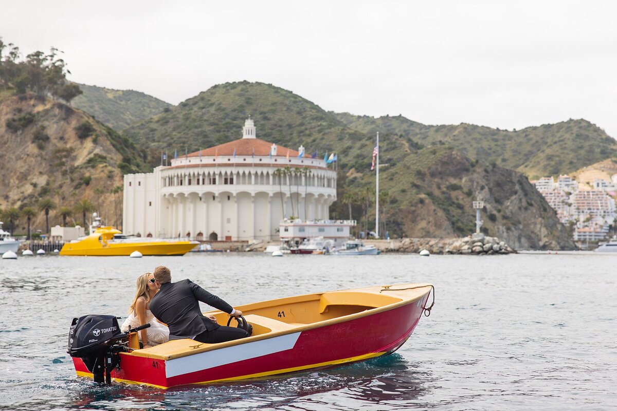 A bride and groom kiss on a boat on their elopement day.