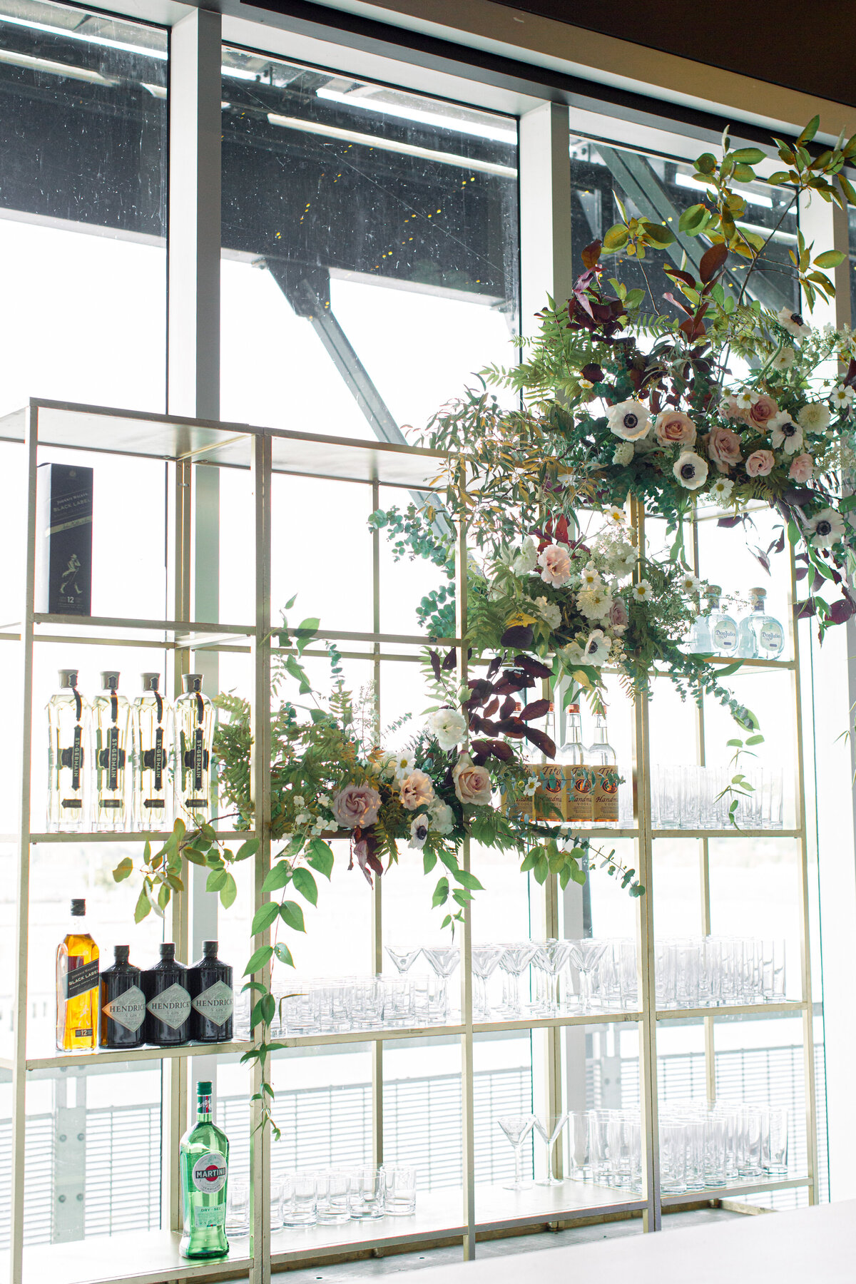 A lush flower arrangement draped across a wedding barback at The Science Centre. 