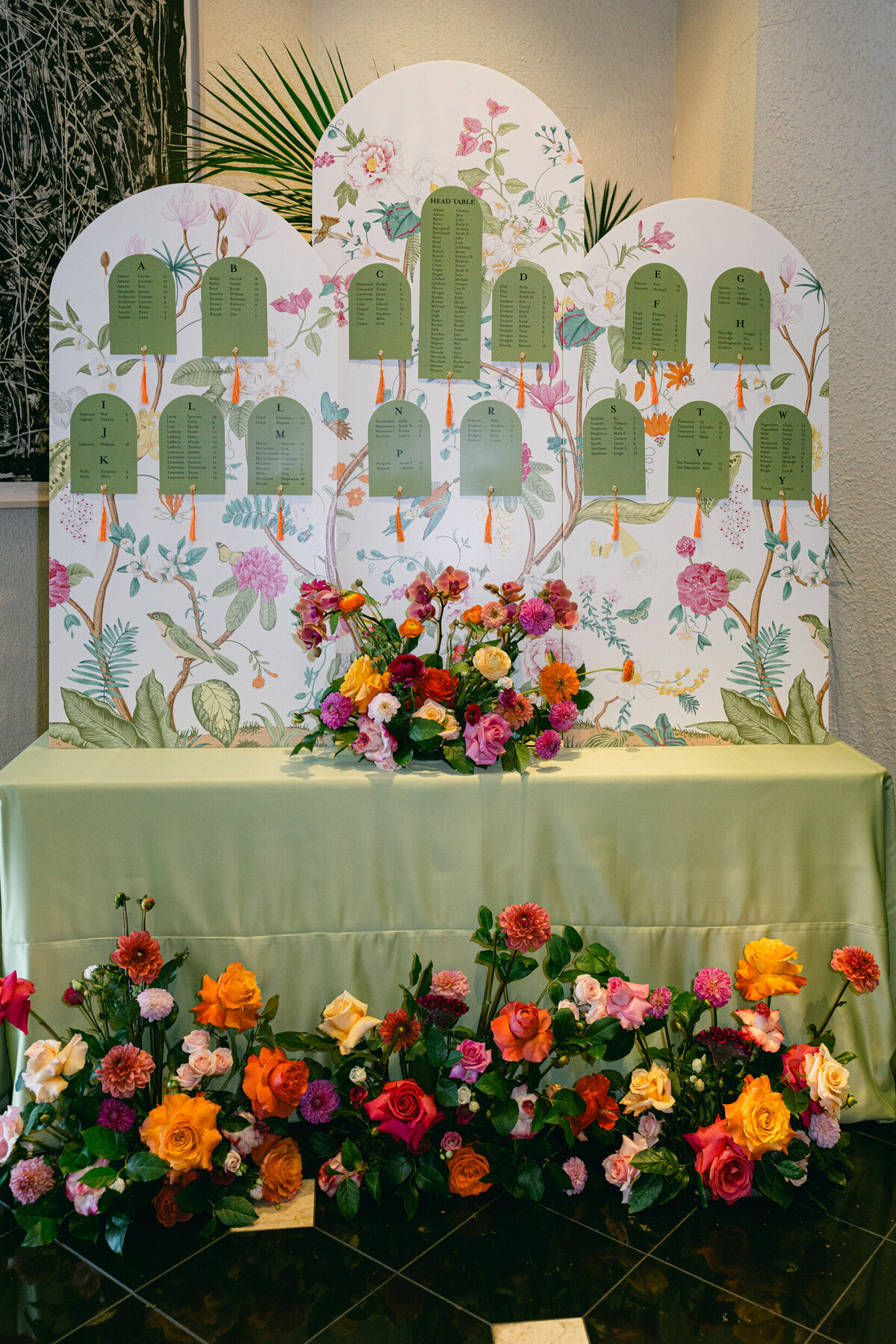 A wedding day photo showing off the wall decoration that has the seating guide for guests