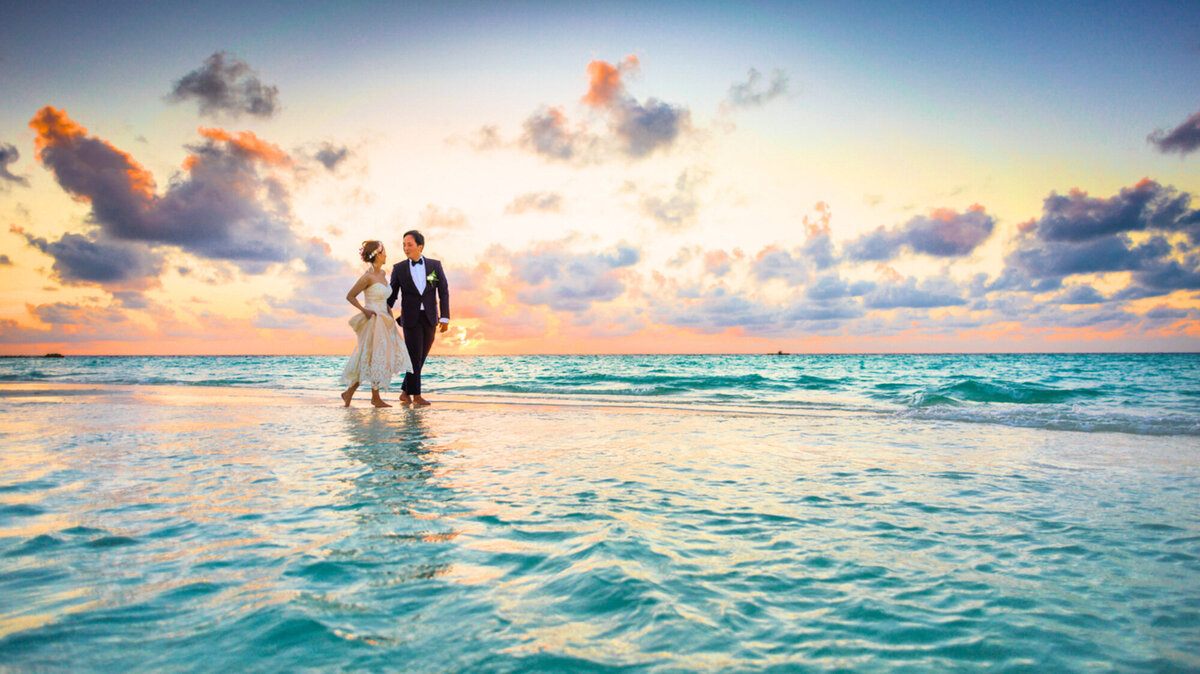 Bride and groom walking at the sea
