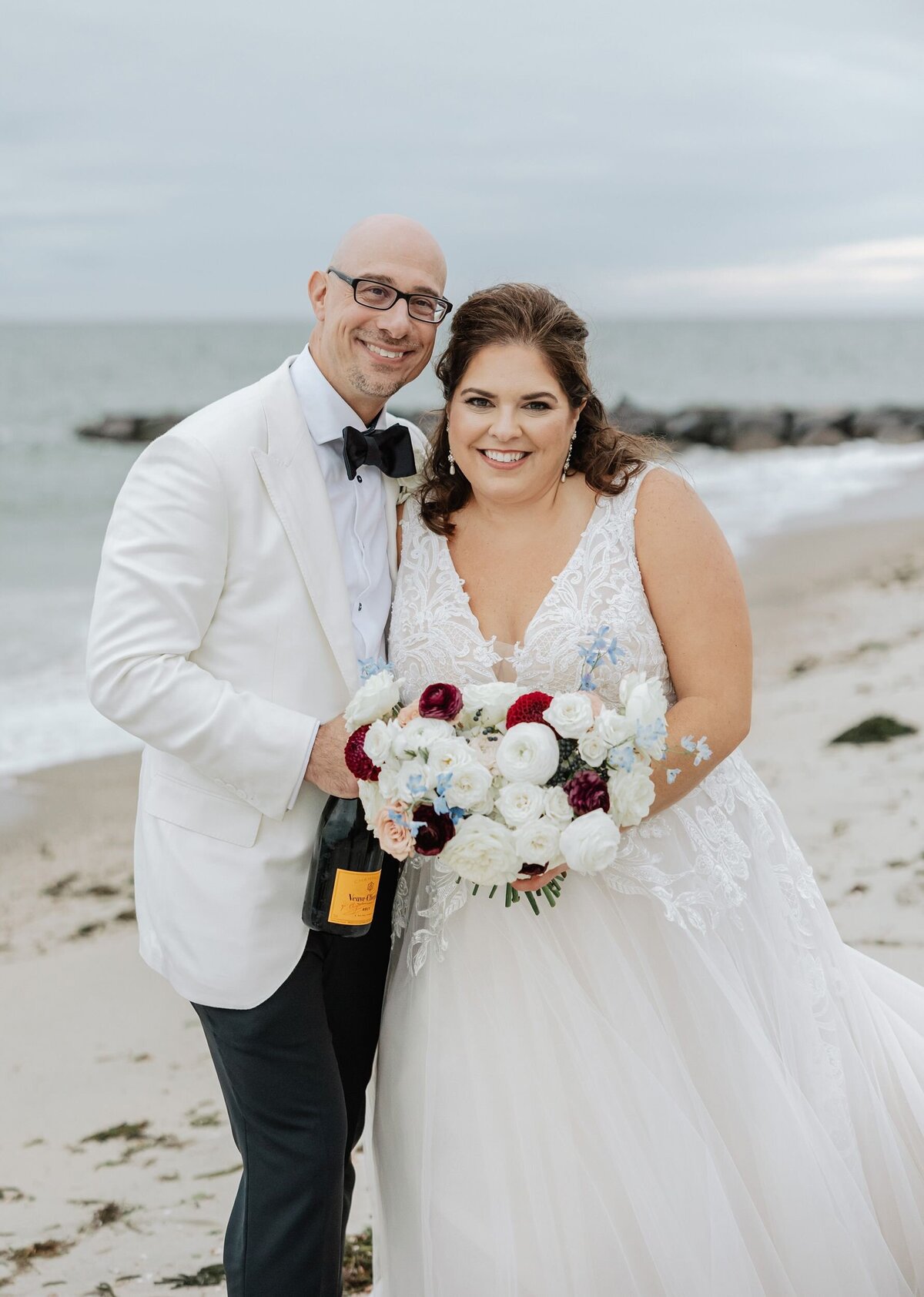 Bride and groom on beach with champagne