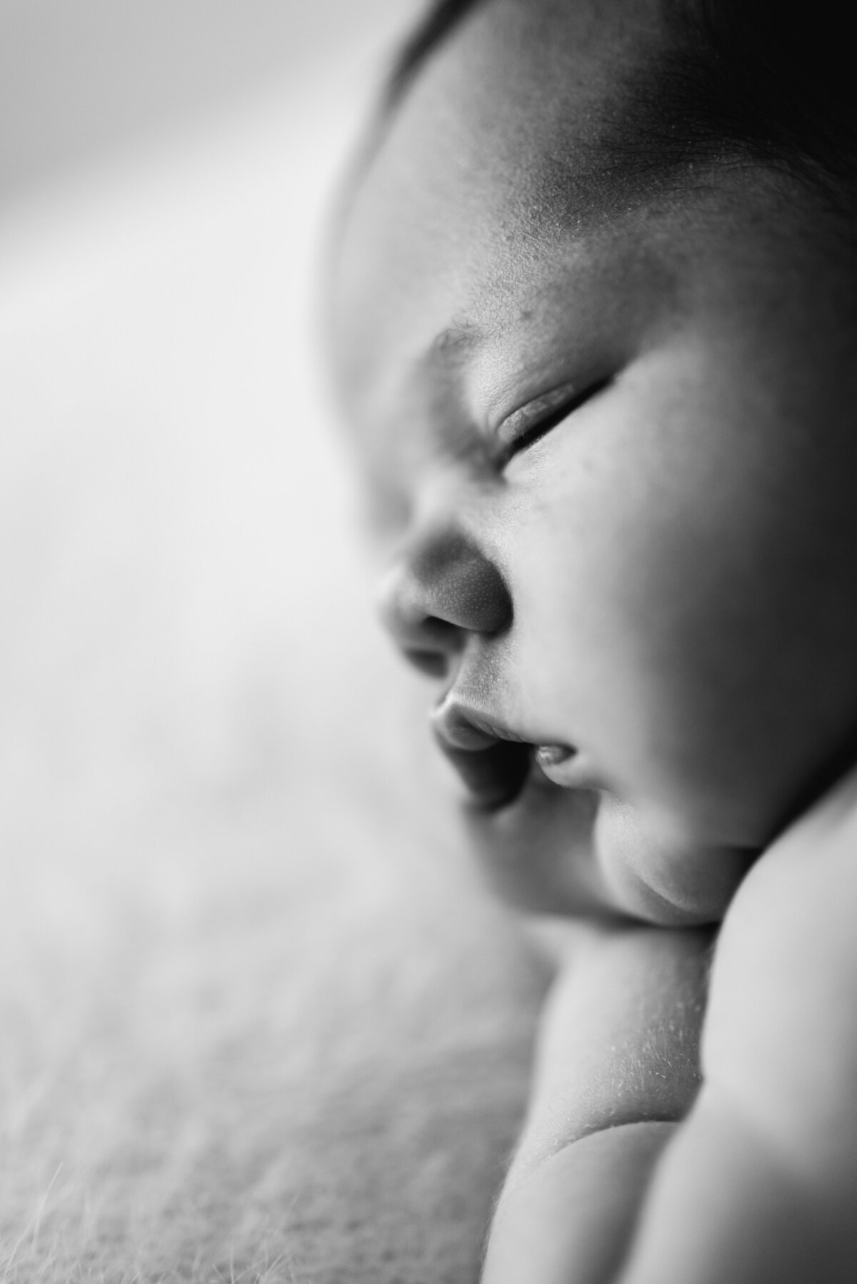 Close up photo of baby boy sleeping at west sussex newborn photoshoot