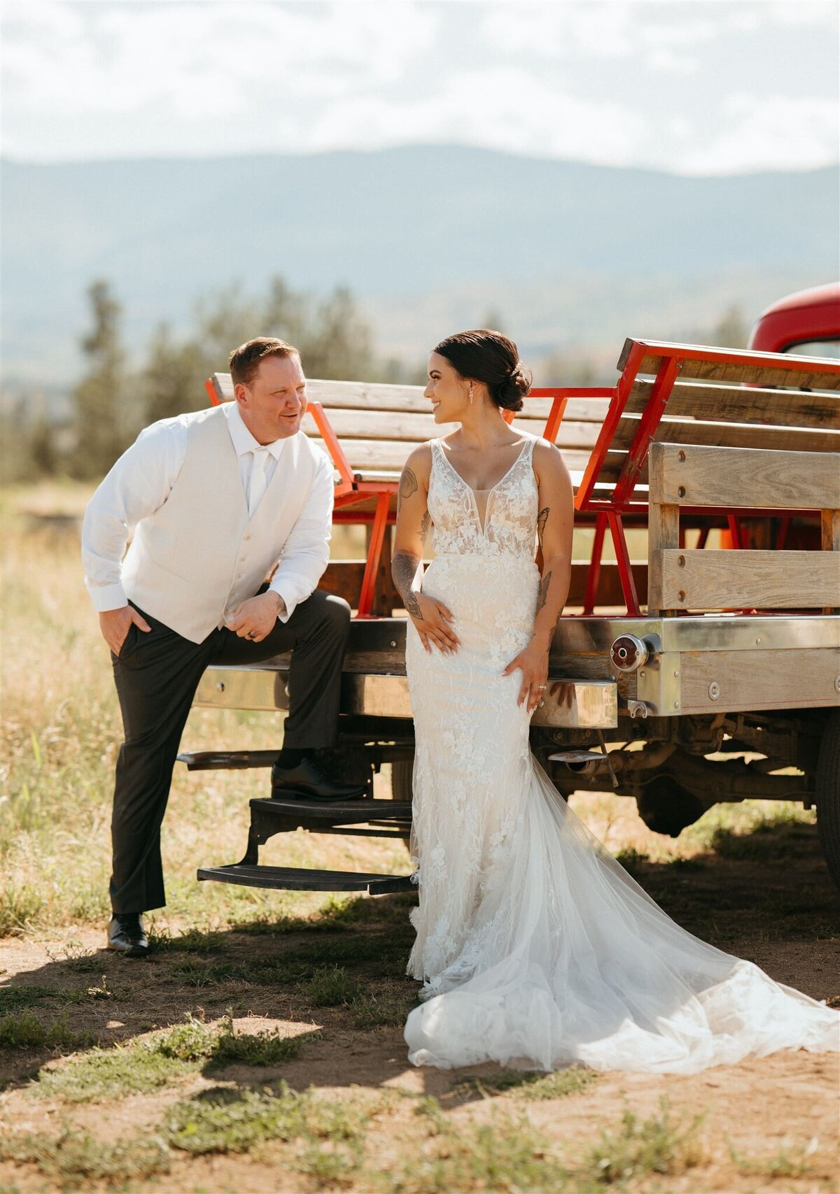 an elegant couple leaning against a truck at Covert Farms
